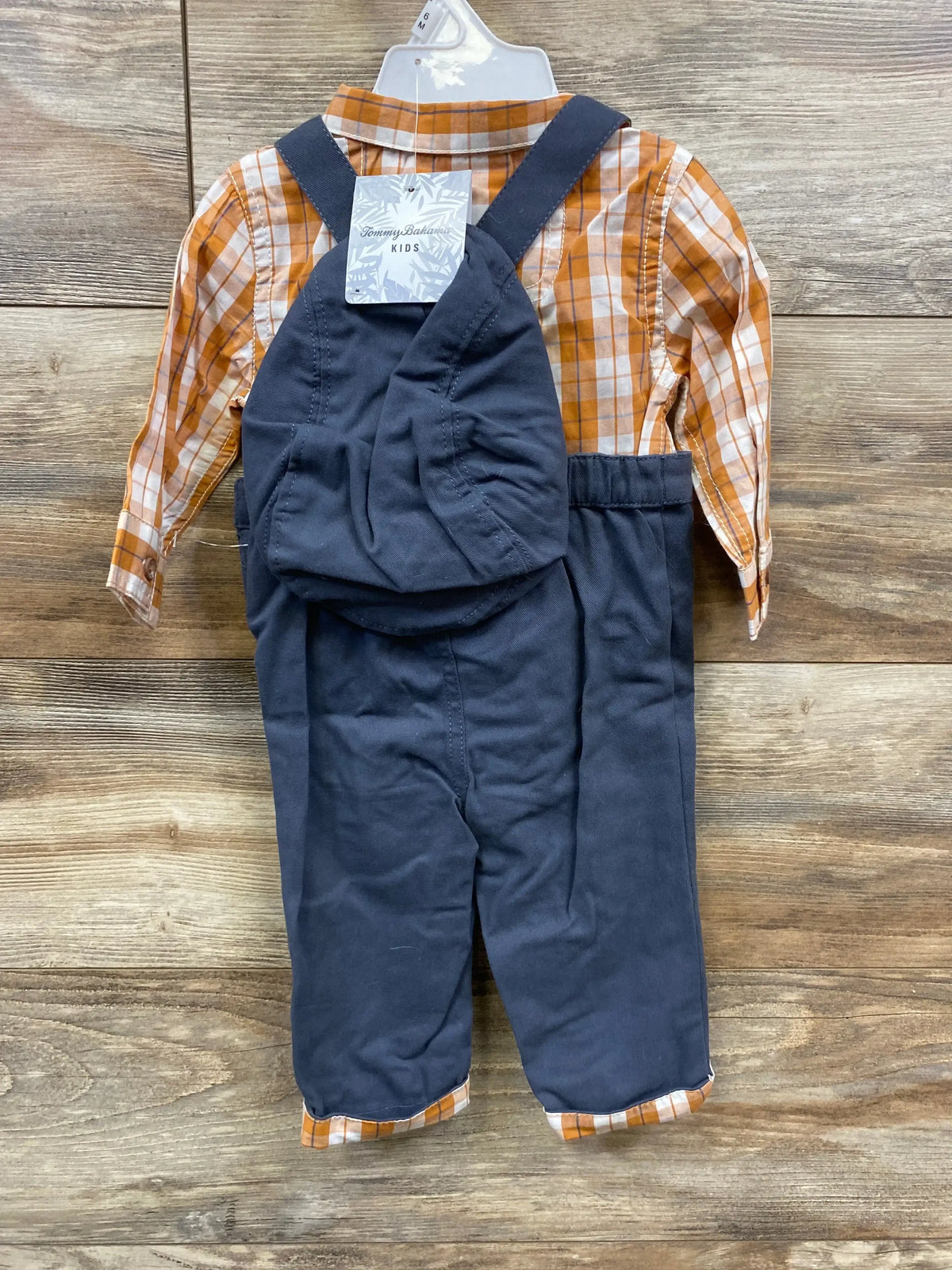 Kids' navy overalls with orange plaid shirt set on wood background, resale clothing