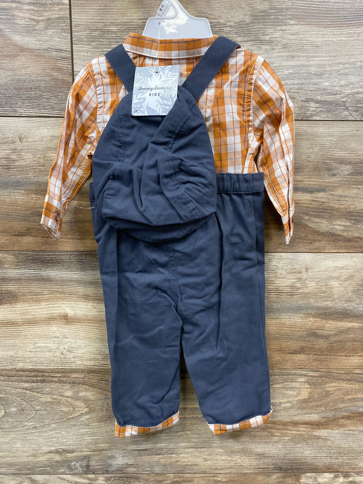 Kids' navy overalls with orange plaid shirt set on wood background, resale clothing