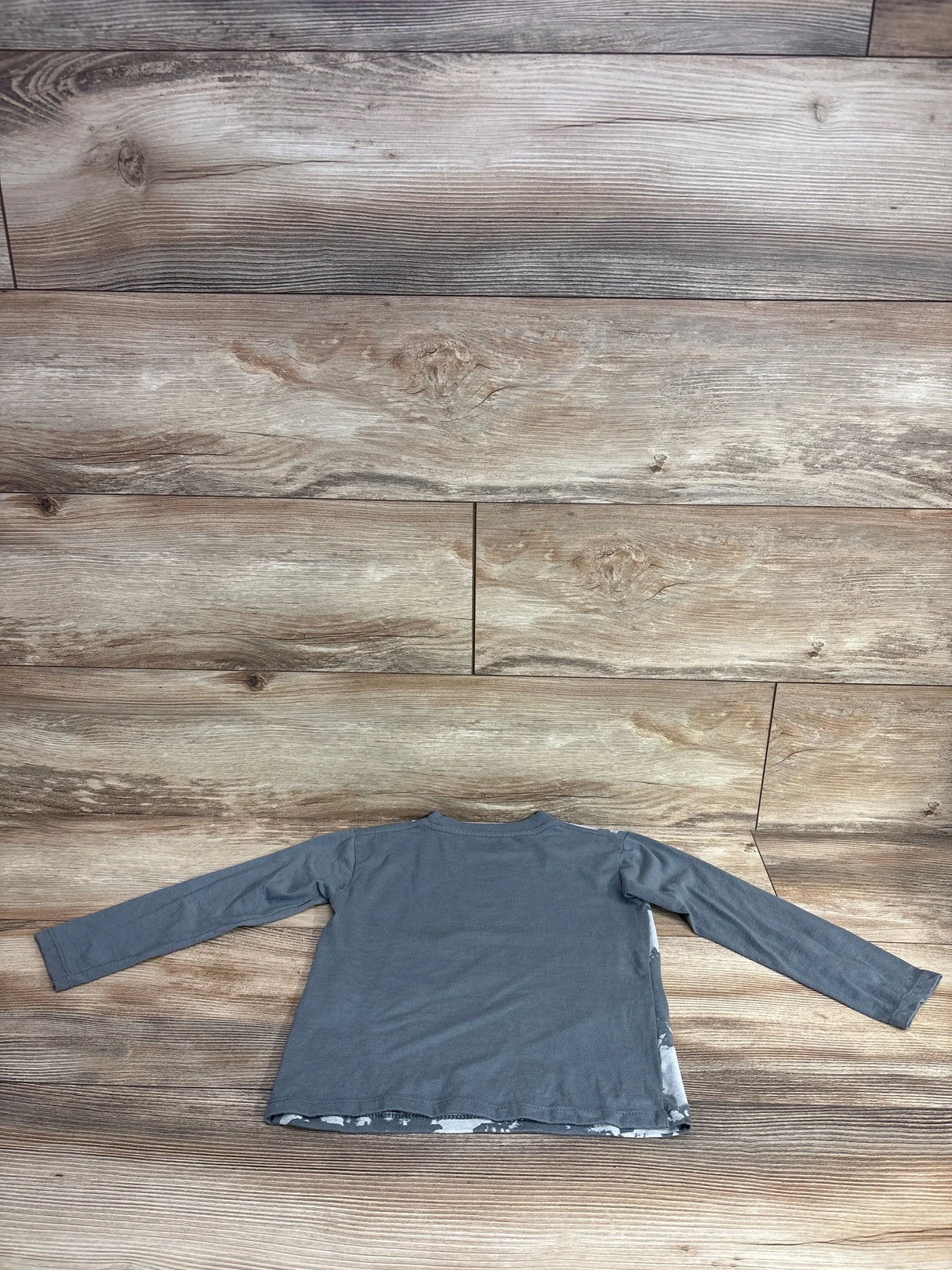 Back view of Extreme Concepts Legend Long Sleeve Shirt in grey size 2T showcasing solid back panel on wood plank floor