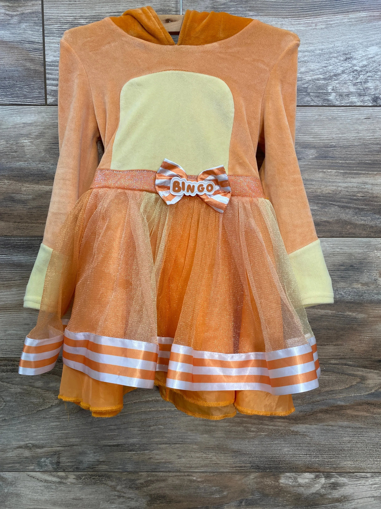 Orange and yellow kids dress with 'BINGO' bow, striped hem, and tulle skirt for festive occasions