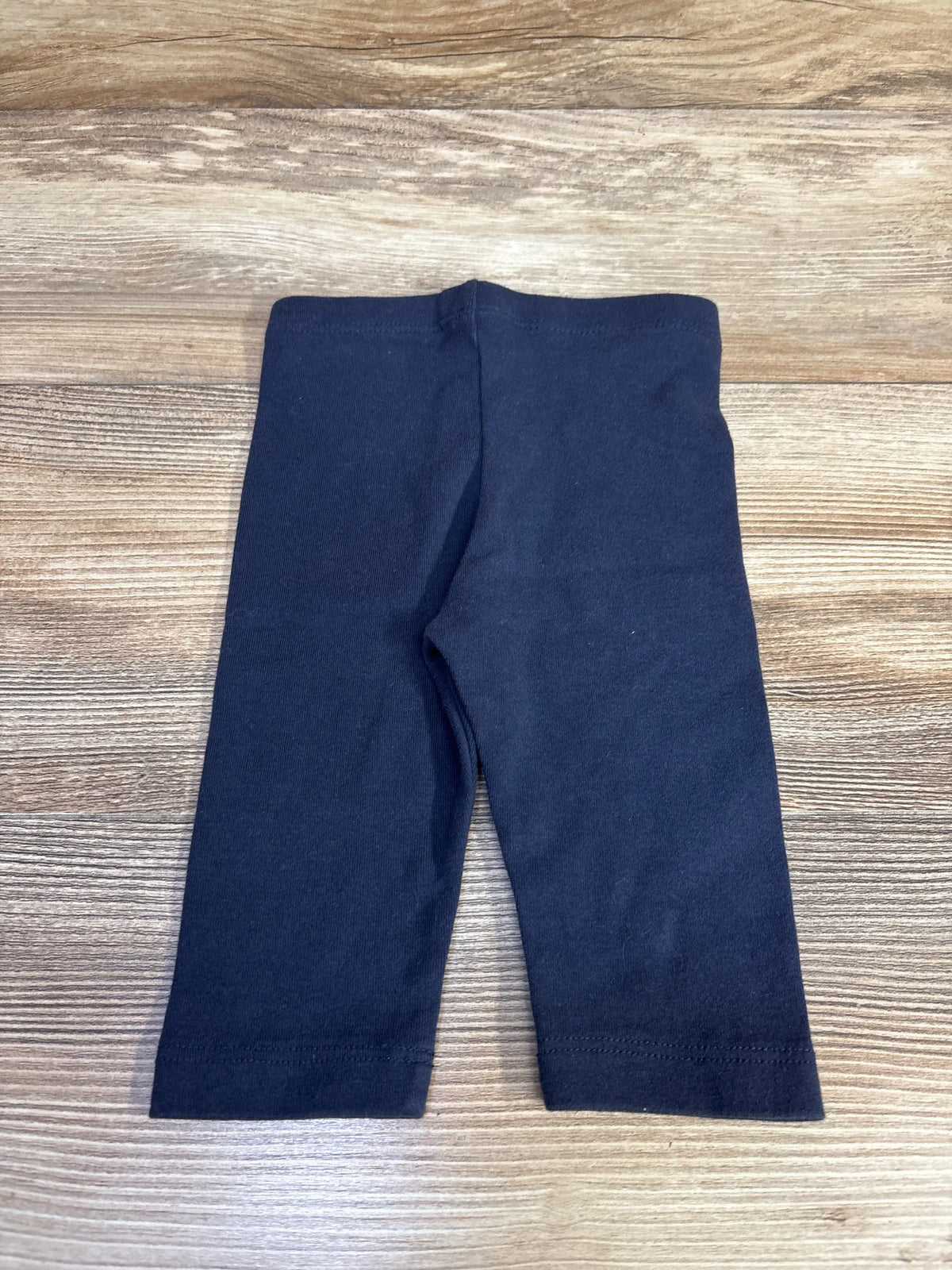 Front view of City Threads long bike shorts in navy, showcasing long legs with a wood-grain background