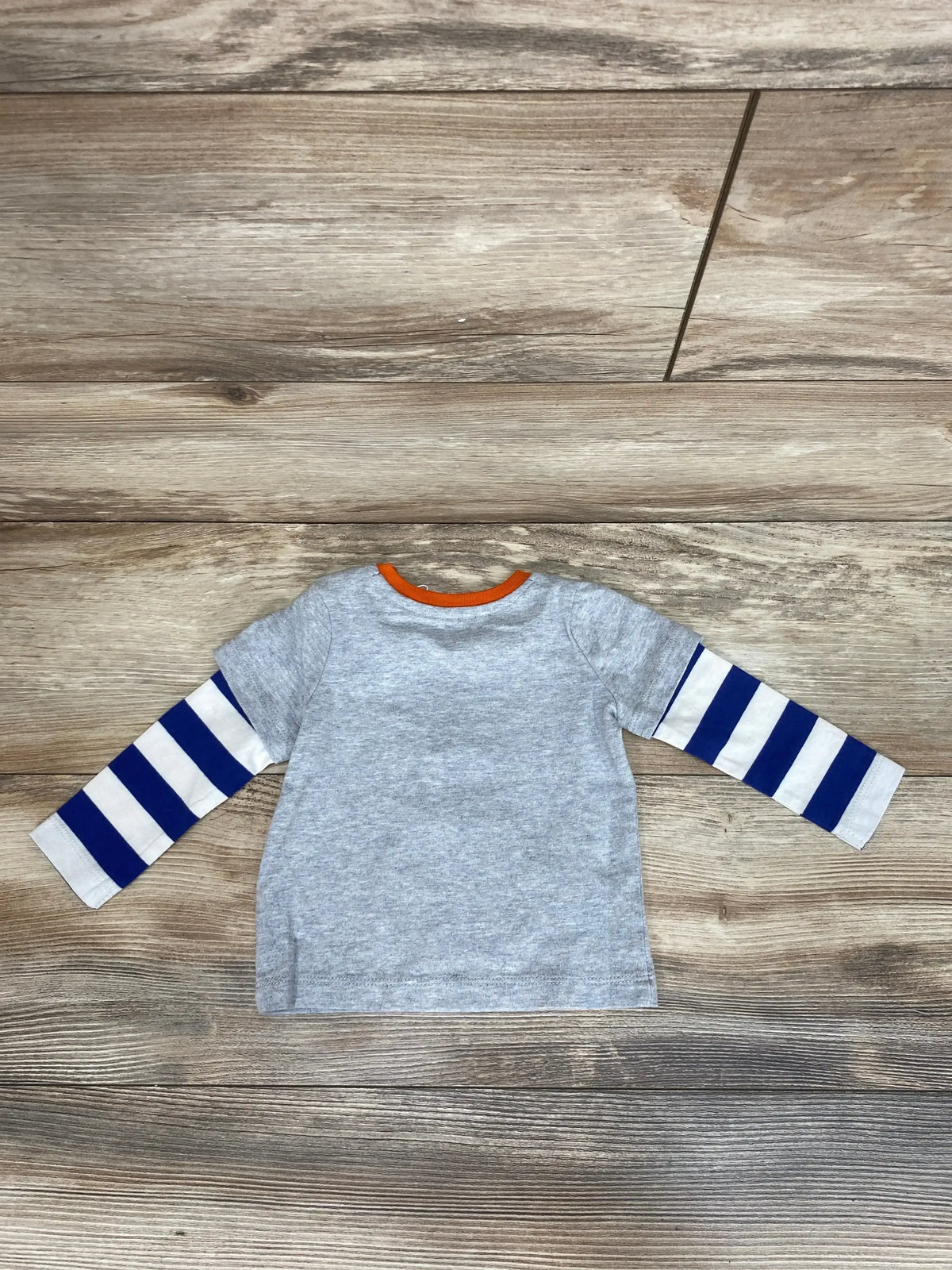 Flat lay of Baby Boden 2fer shirt in size 3-6m with gray short sleeves, striped blue-and-white long sleeves, and orange trim