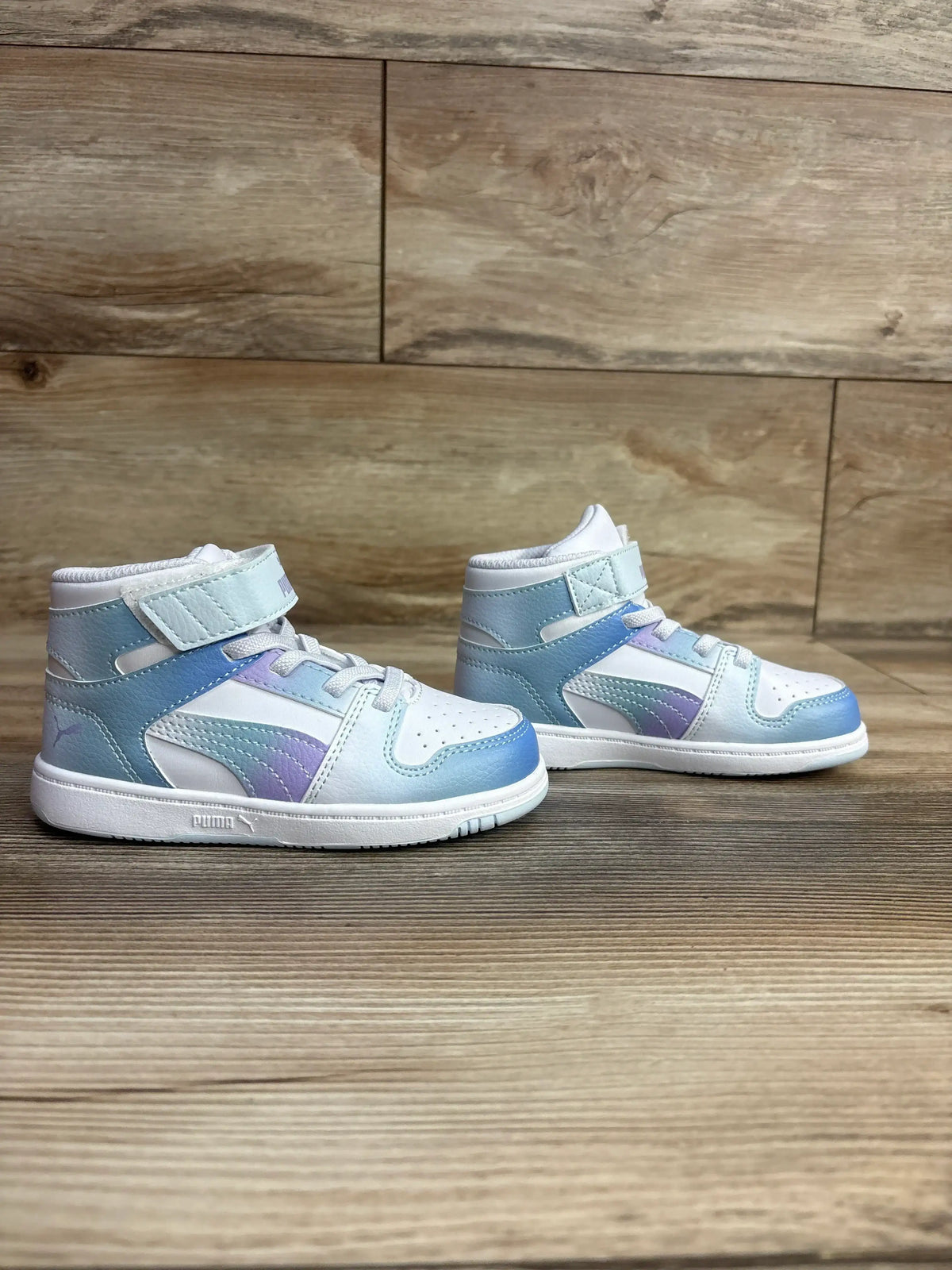 Side view of Puma Rebound Layup Euphoria V toddler high-top sneakers, size 9C, showing pastel blue and purple gradient panels and ankle strap on wooden surface