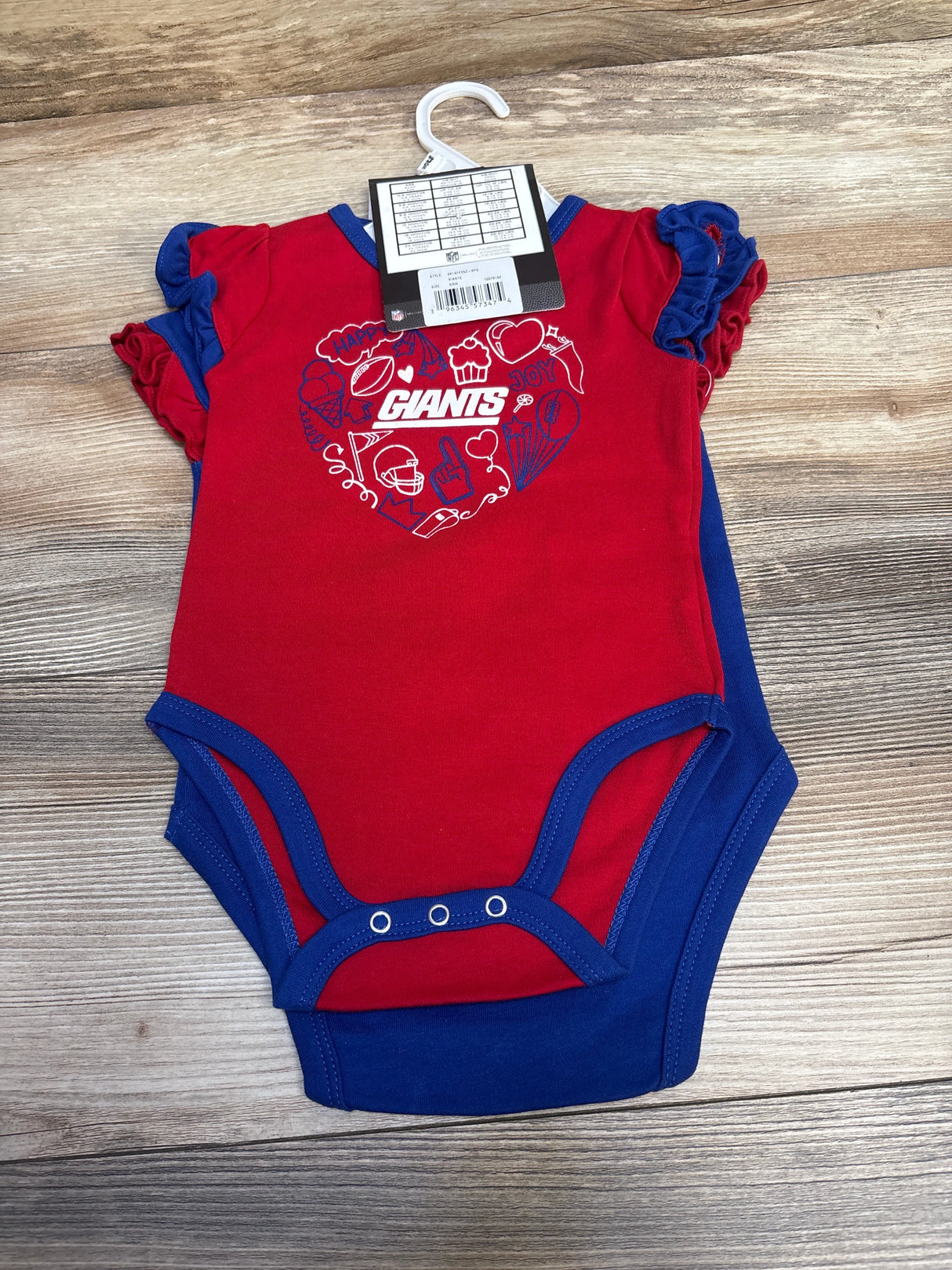 Red and blue New York Giants baby onesie's set with heart-shaped team graphics on wooden background