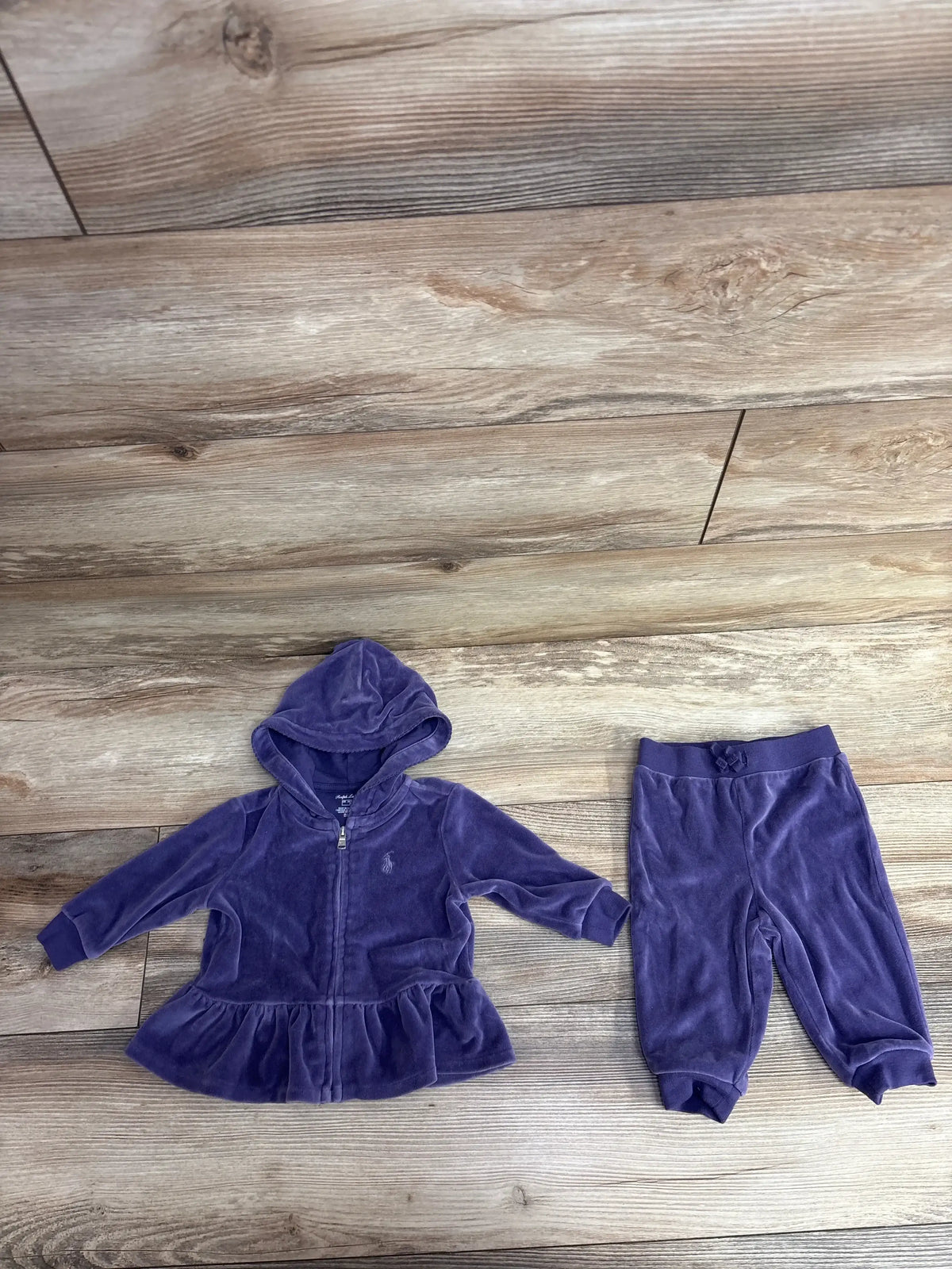 Purple velour baby hoodie with ruffled hem and matching pants on wood floor