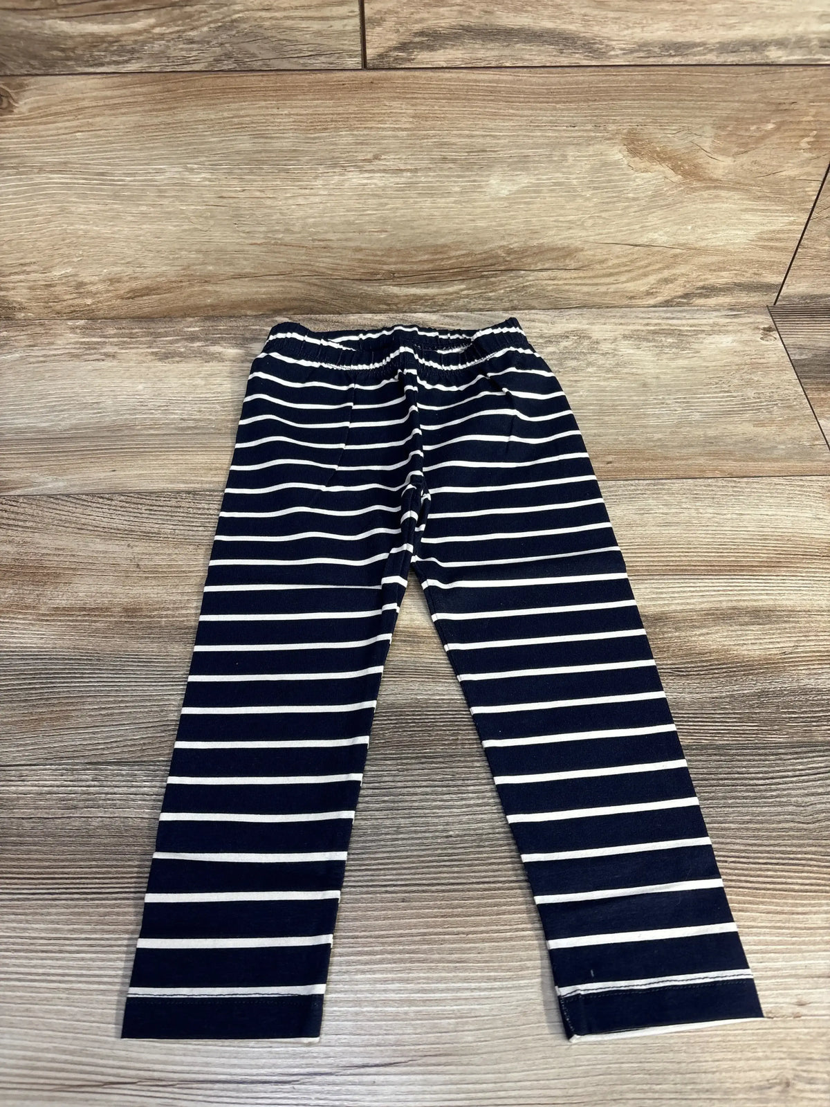 Navy blue and white striped kids leggings on wooden floor