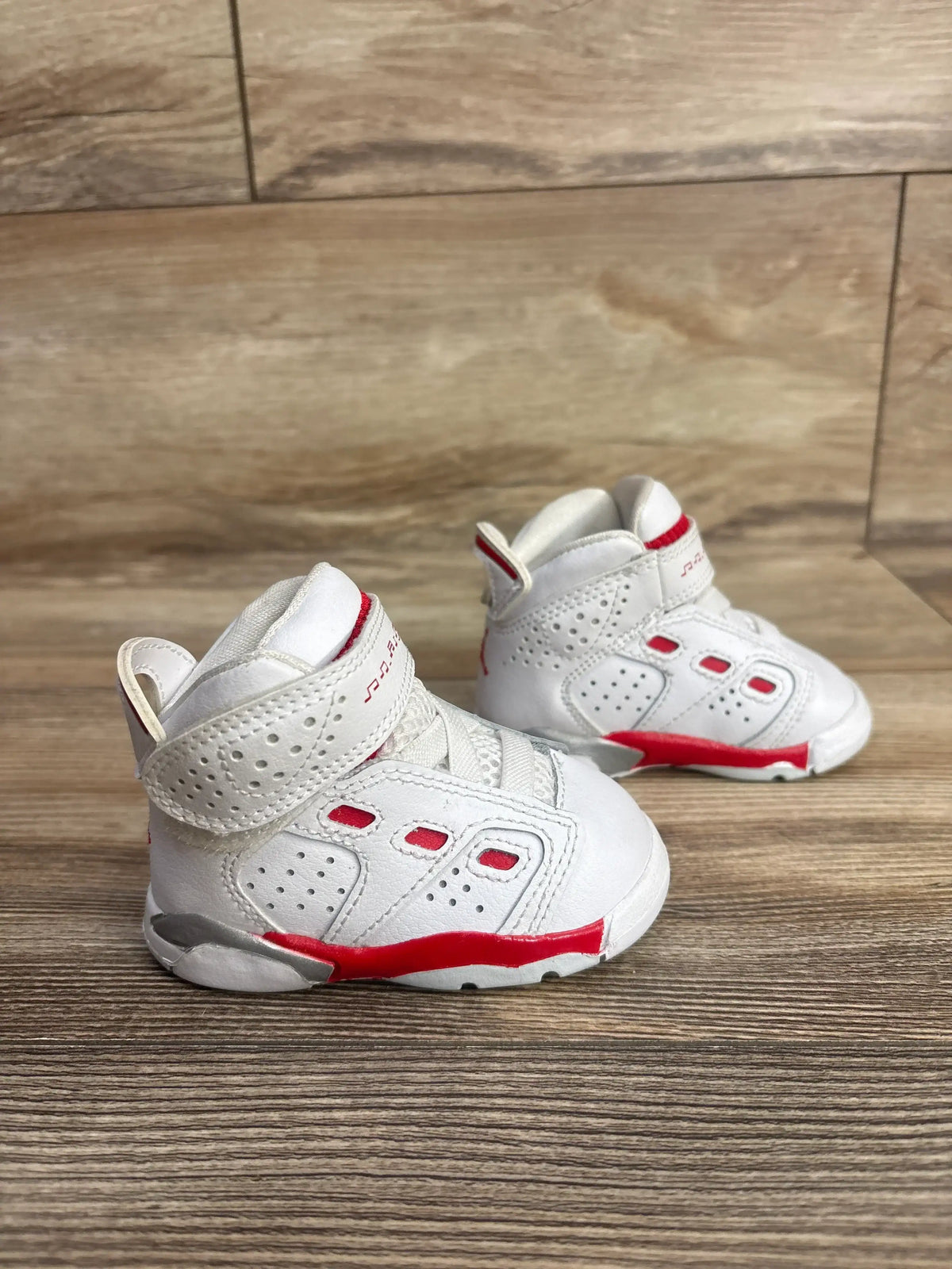 Side view of Air Jordan 6-17-23 TD toddler sneakers size 3C showcasing white leather, Velcro strap and red midsole accents on wooden floor