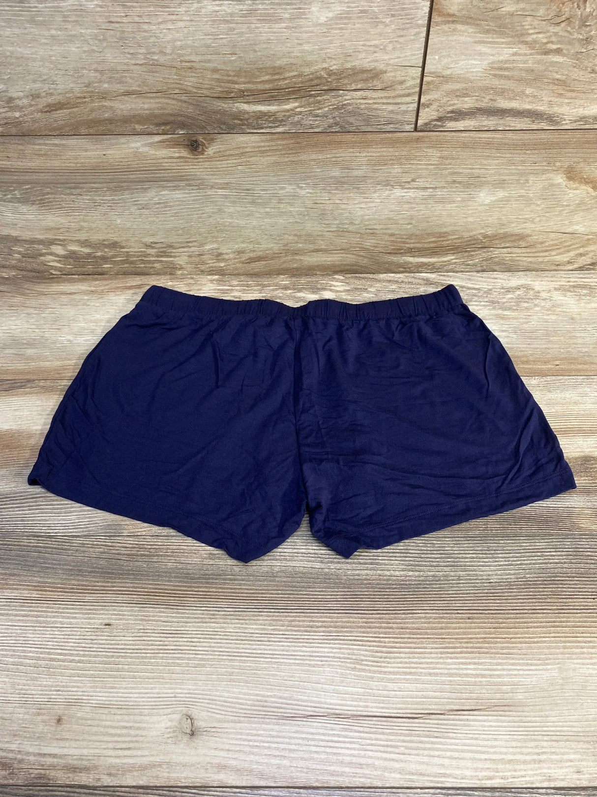 Top-down view of navy Gap Body maternity modal shorts showing elastic waistband and soft fabric on wood background