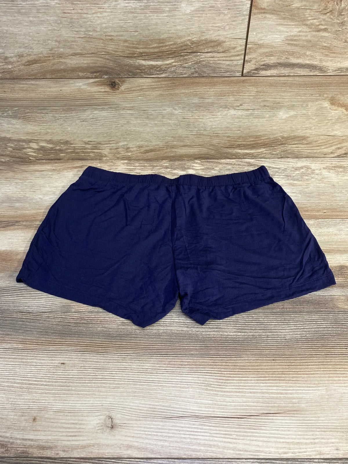 Top-down view of navy Gap Body maternity modal shorts showing elastic waistband and soft fabric on wood background