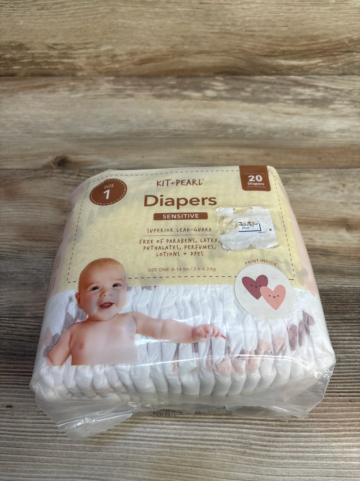 Kit and Pearl Sensitive diapers size 1 pack with baby image on wooden background