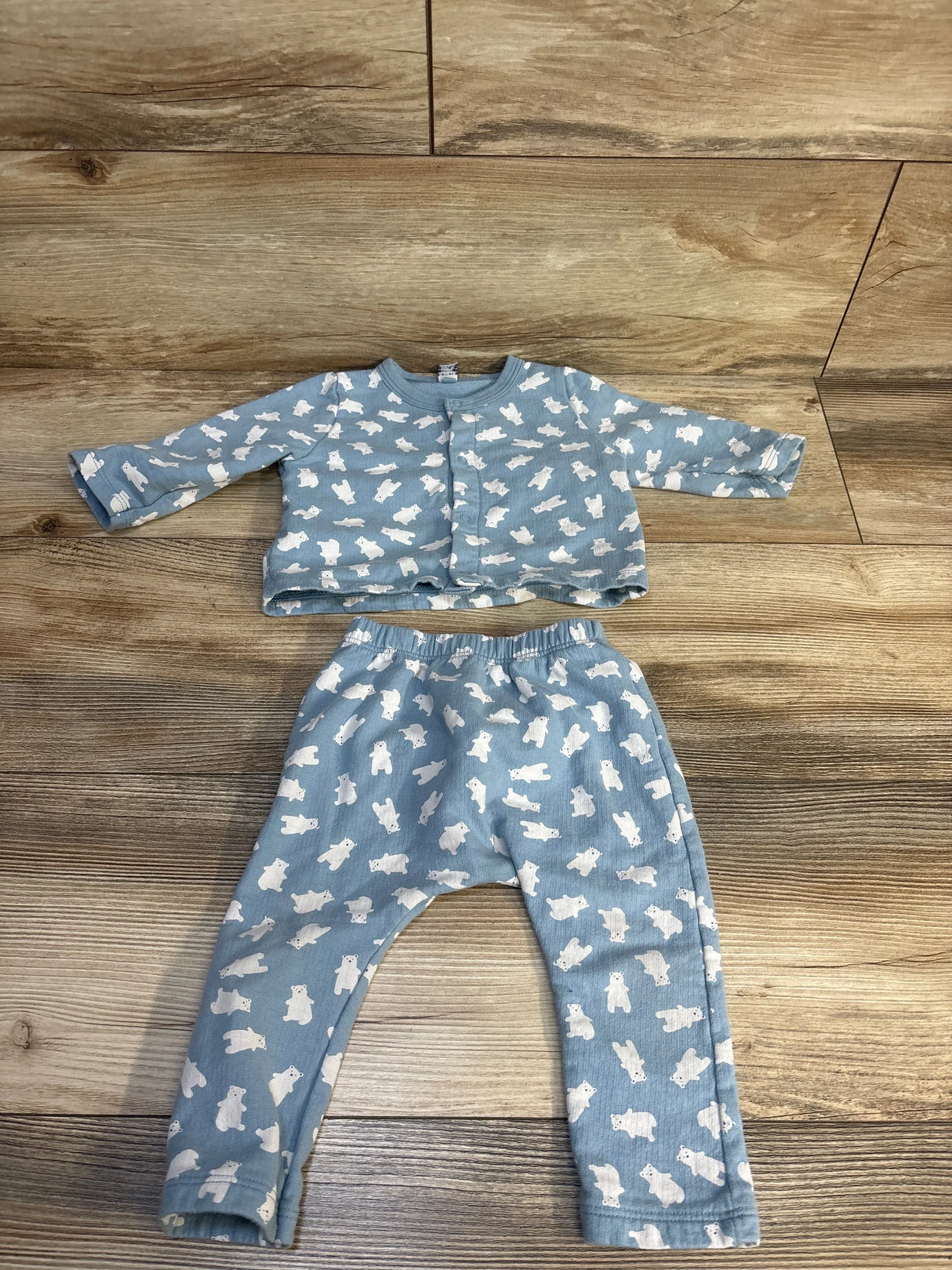 Blue baby outfit set with white bear print, includes long sleeve top and pants, laid flat on wood