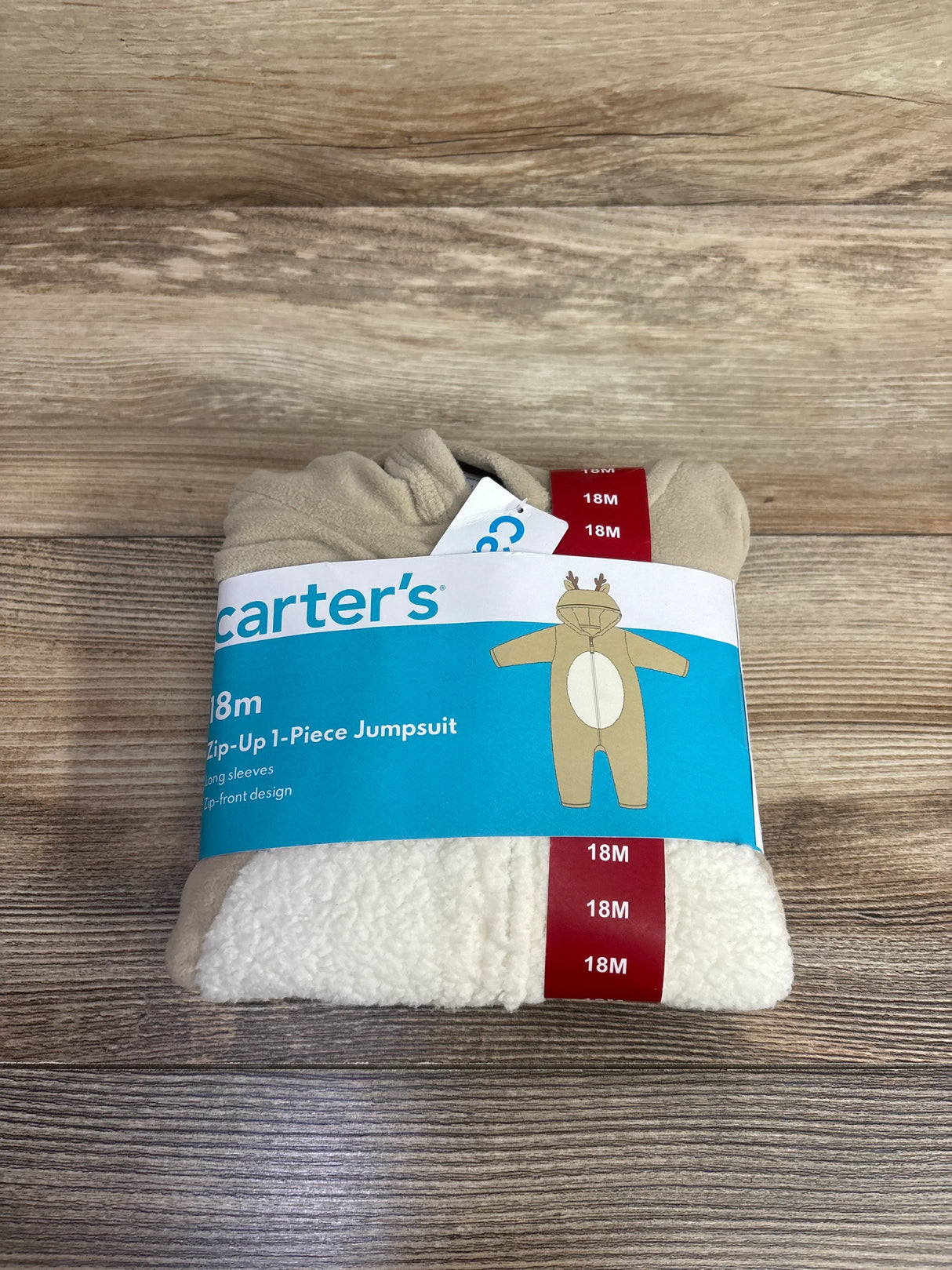 Beige and white fleece baby jumpsuit size 18M, Carter's zip-up one-piece, folded on wood