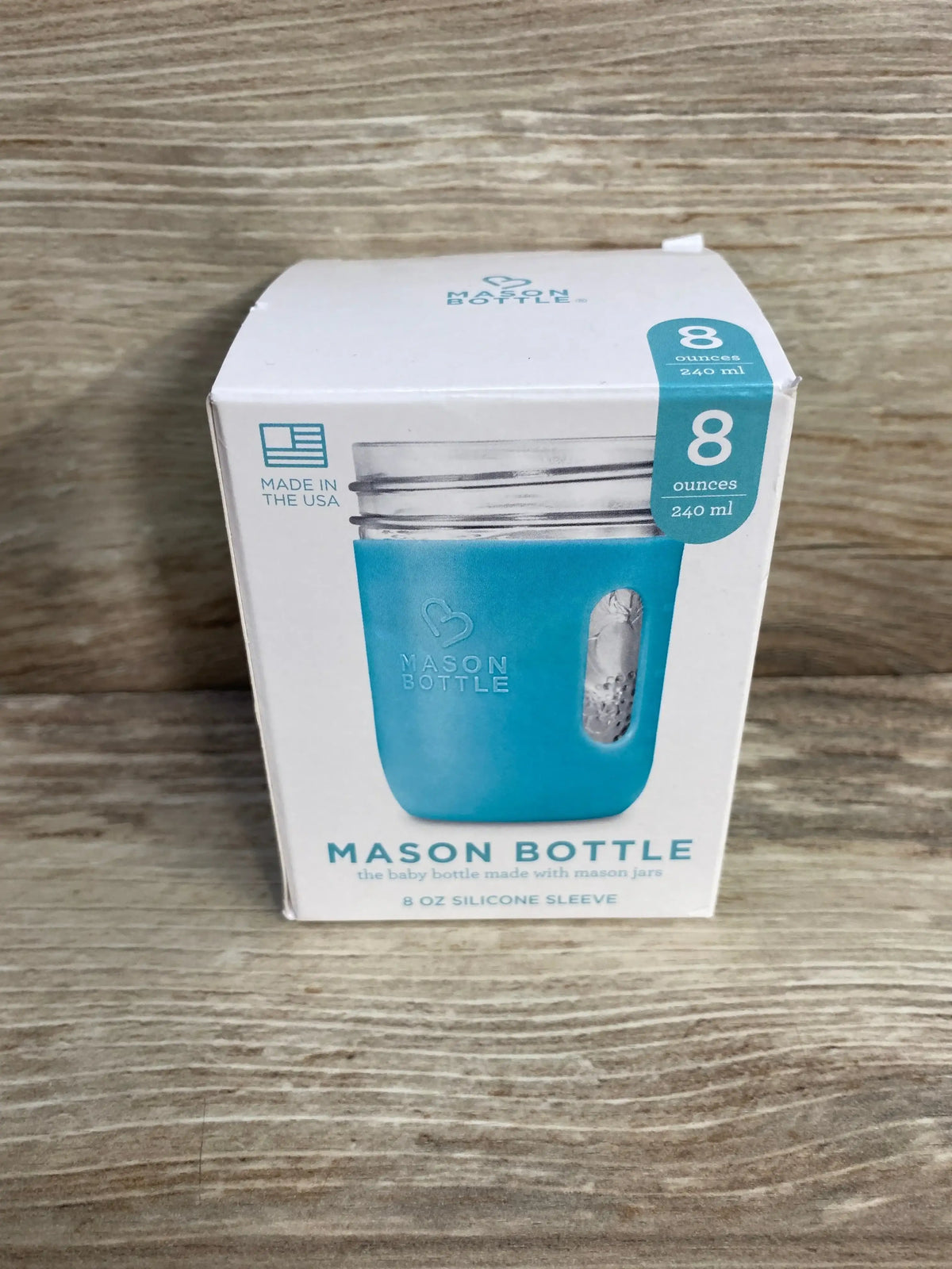 Front view of Mason Bottle 8 oz silicone sleeve boxed product showcasing blue sleeve and 8 ounces 240 ml label on a wood tabletop