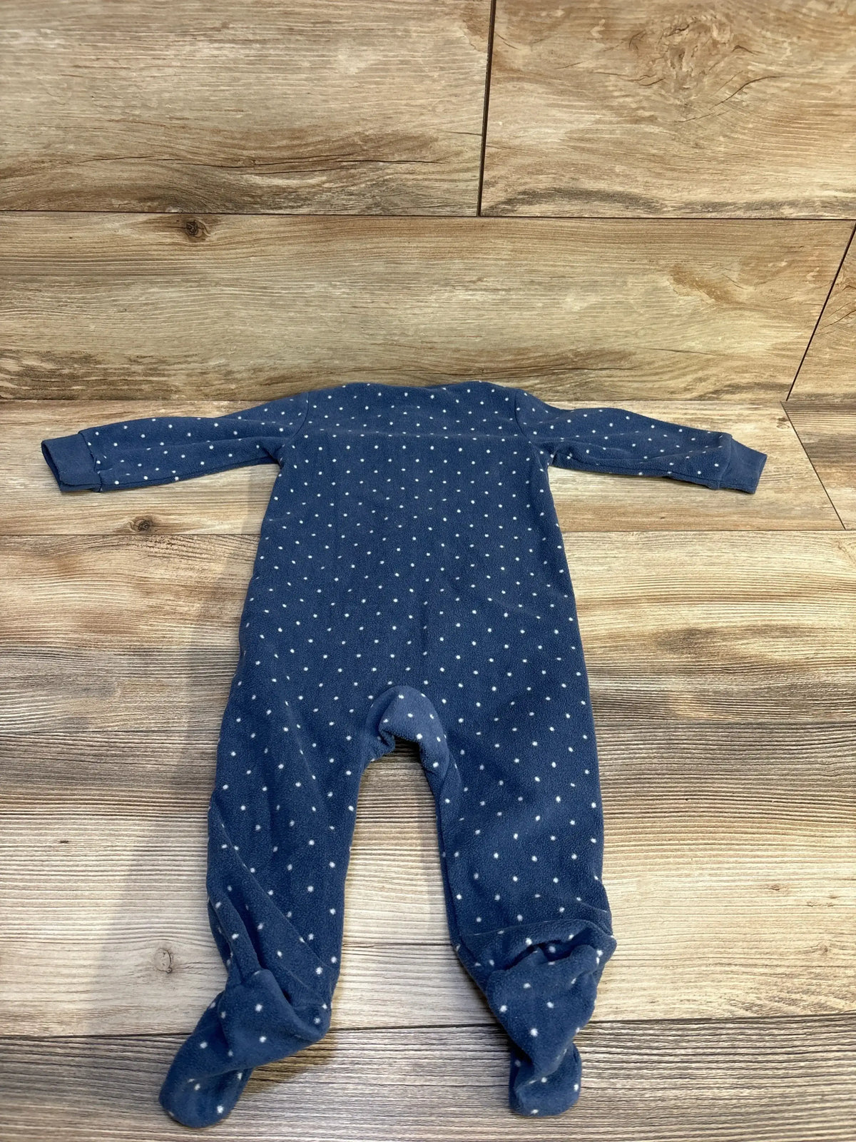 Front view of Carter’s Polka Dot Blanket Sleeper sz 9m showcasing navy blue polka dots, footed legs, and long sleeves on a wood floor