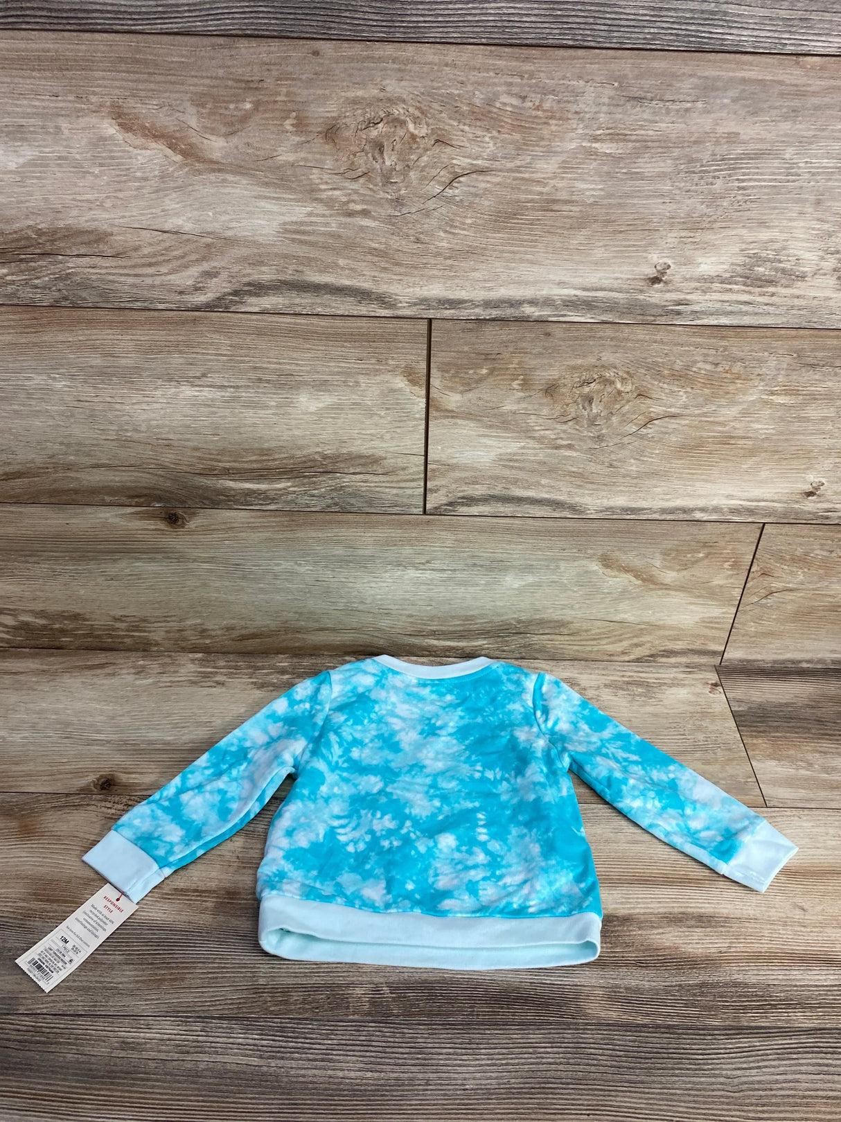 Blue and white tie-dye long sleeve toddler shirt on wood background with tag attached