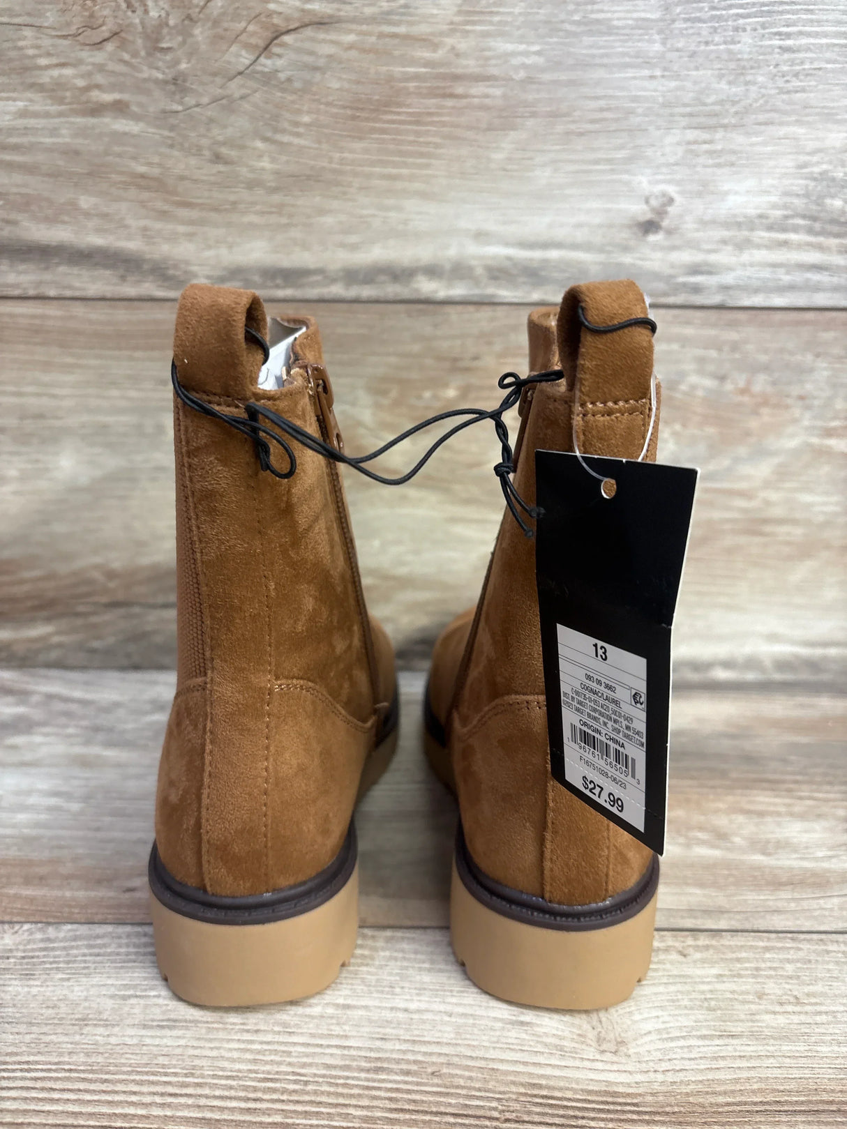 Pair of brown suede kids ankle boots with block soles and price tag, size 13, on wood background