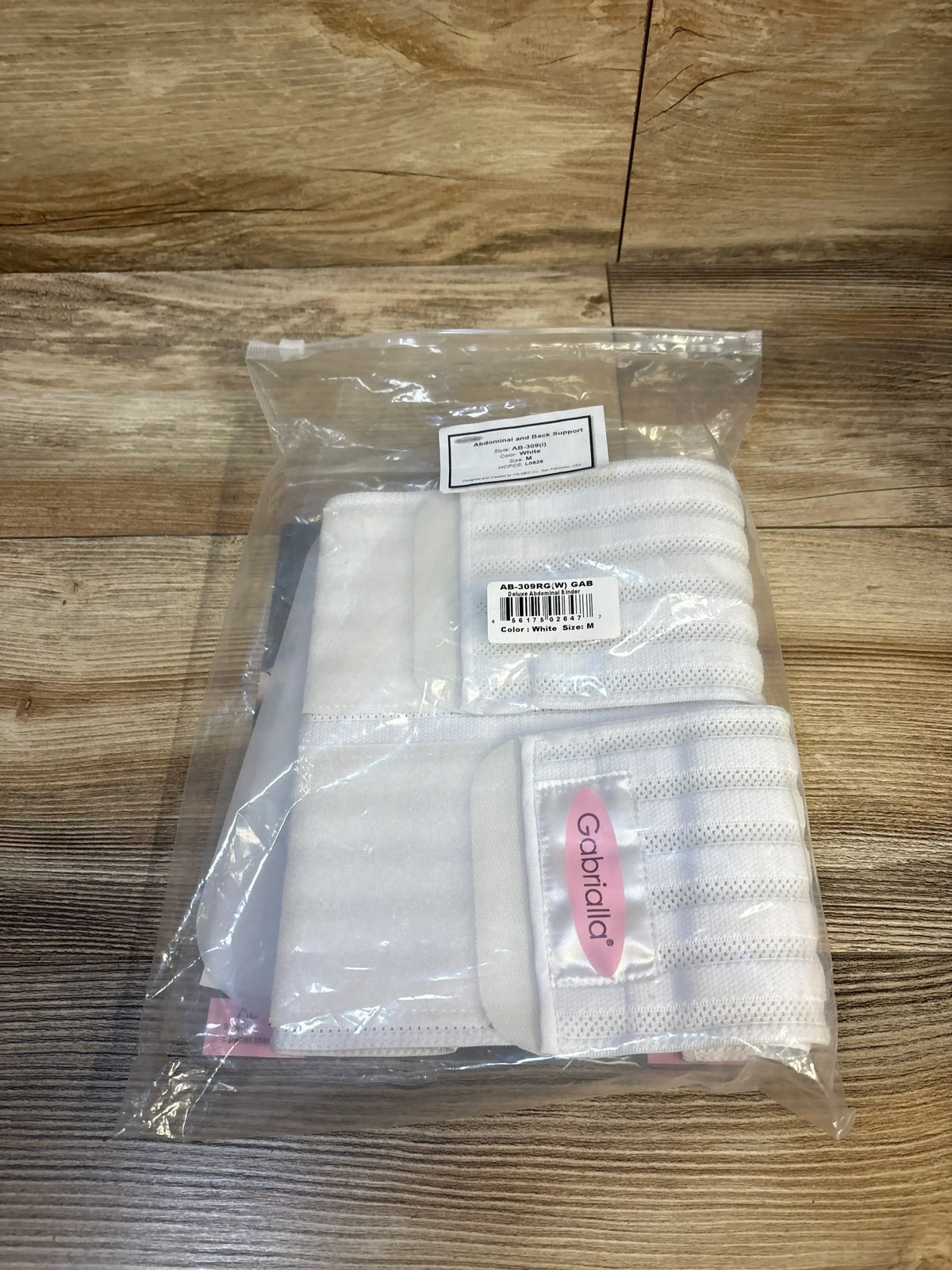 Packaged white Gabriella abdominal and back support maternity belt on wood surface