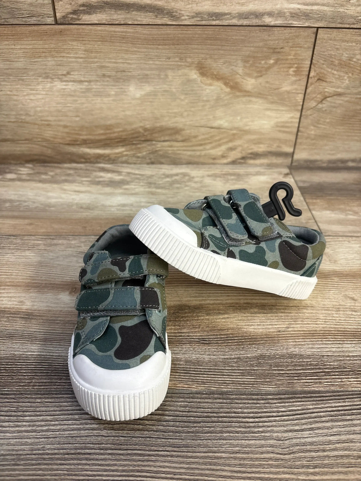 Front and side view of green camouflage Wonder Nation sneakers with double straps and white bump toes on wood floor