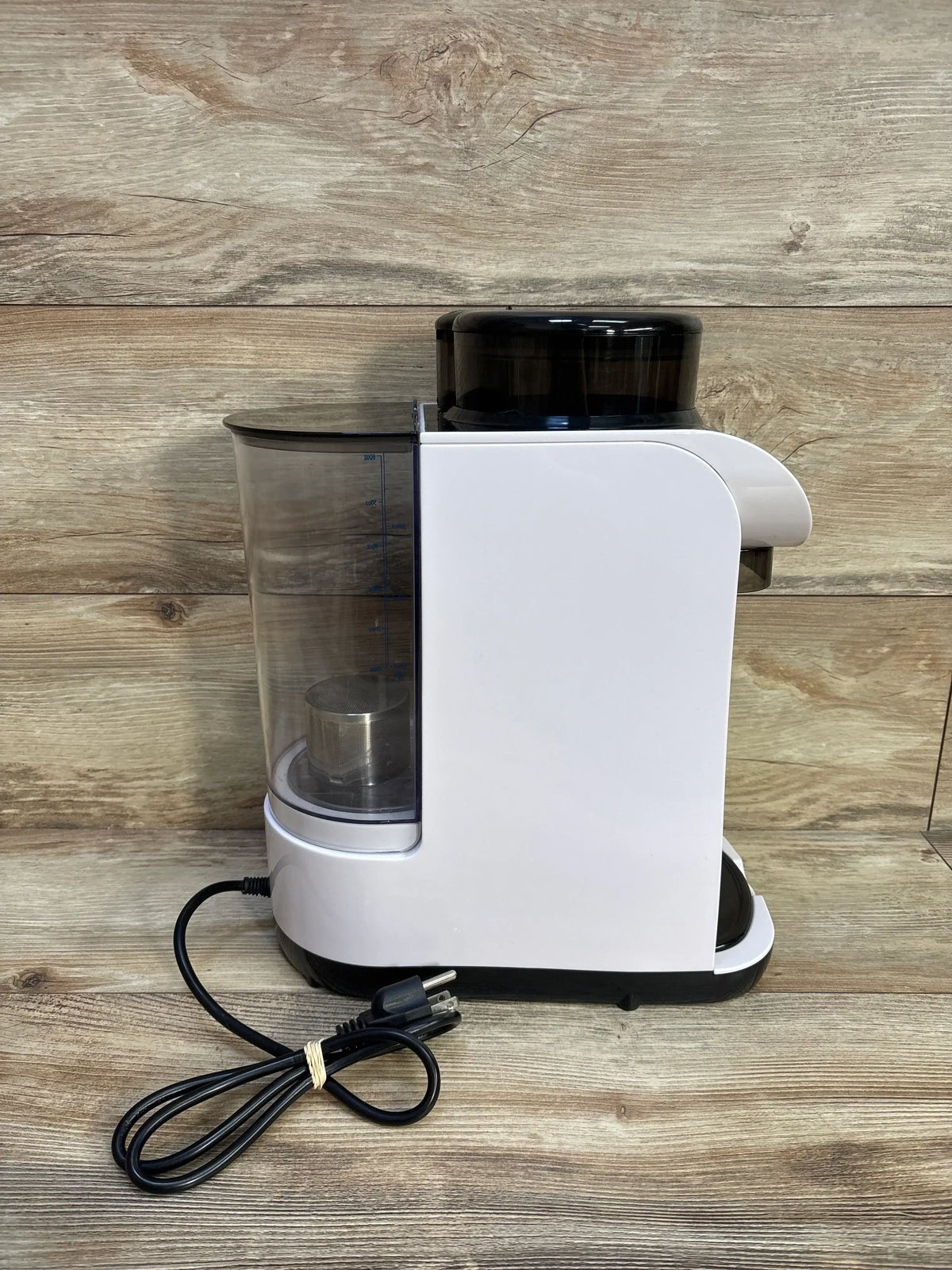 Side view of Baby EXO Smart Formula Maker/Dispenser with clear reservoir, measurement markings, and black formula container
