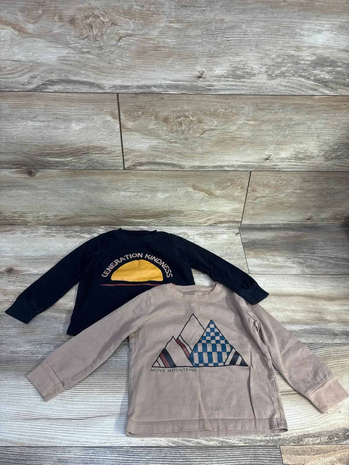 Front view of 2-pack Little Star Organic long-sleeve toddler shirts showing crew necks and soft cotton fabric in black and brown on white background