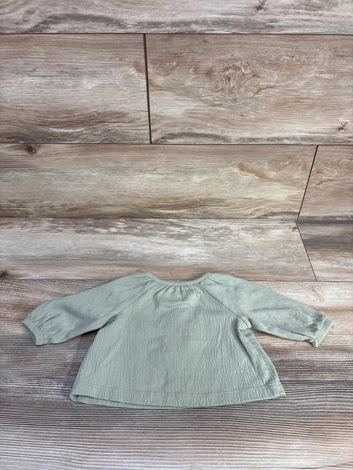 Front view of Carter’s long sleeve green henley baby shirt size 3 months showing three-button placket on white background