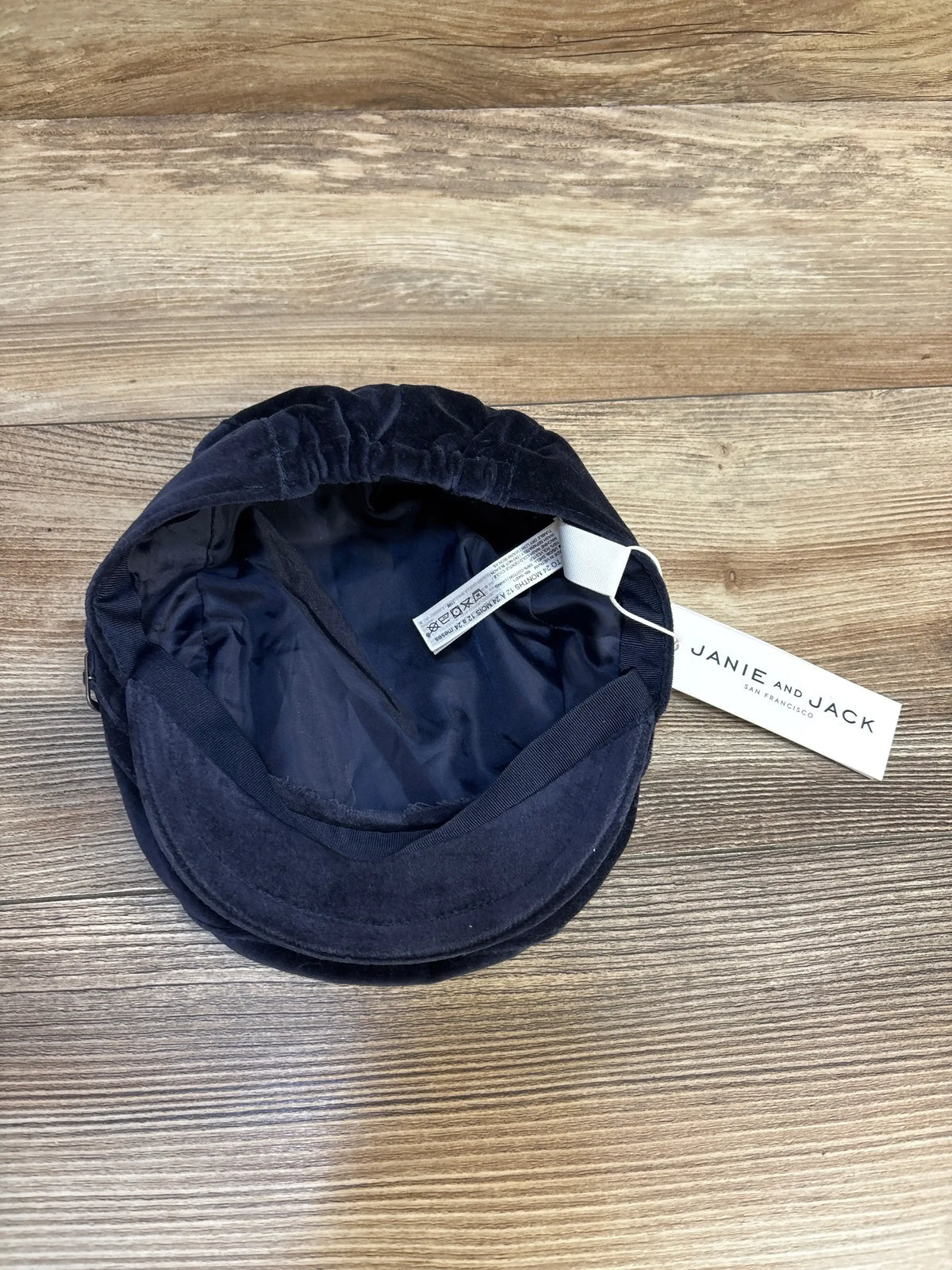 Navy blue Janie and Jack toddler hat with tag, displayed on wood surface
