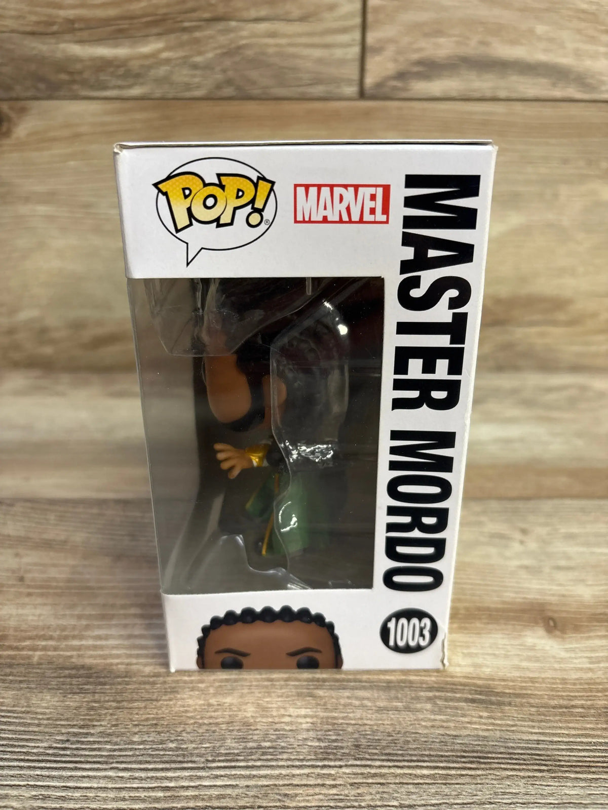 Front-right view of Master Mordo Funko Pop in windowed box showing the figure, Pop and Marvel logos on a wood tabletop
