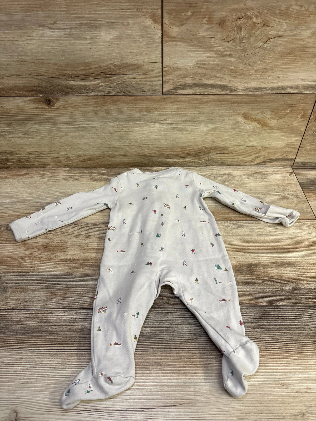 Front view of Little Planet Organic Holiday Sleeper in beige, showcasing long sleeves, footed legs, and holiday print