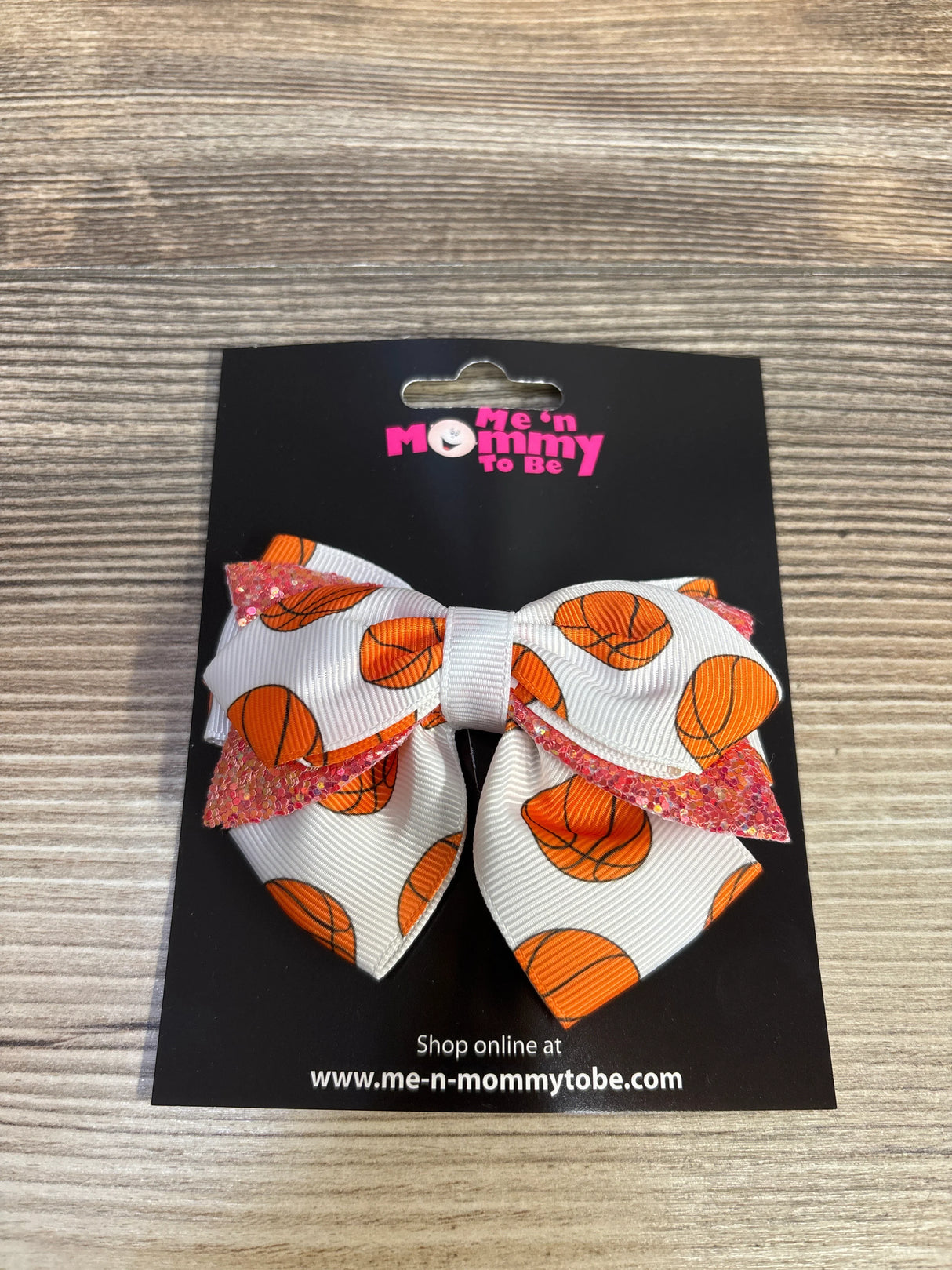 White hair bow with basketball print and pink glitter edges on branded card Me 'n Mommy To Be