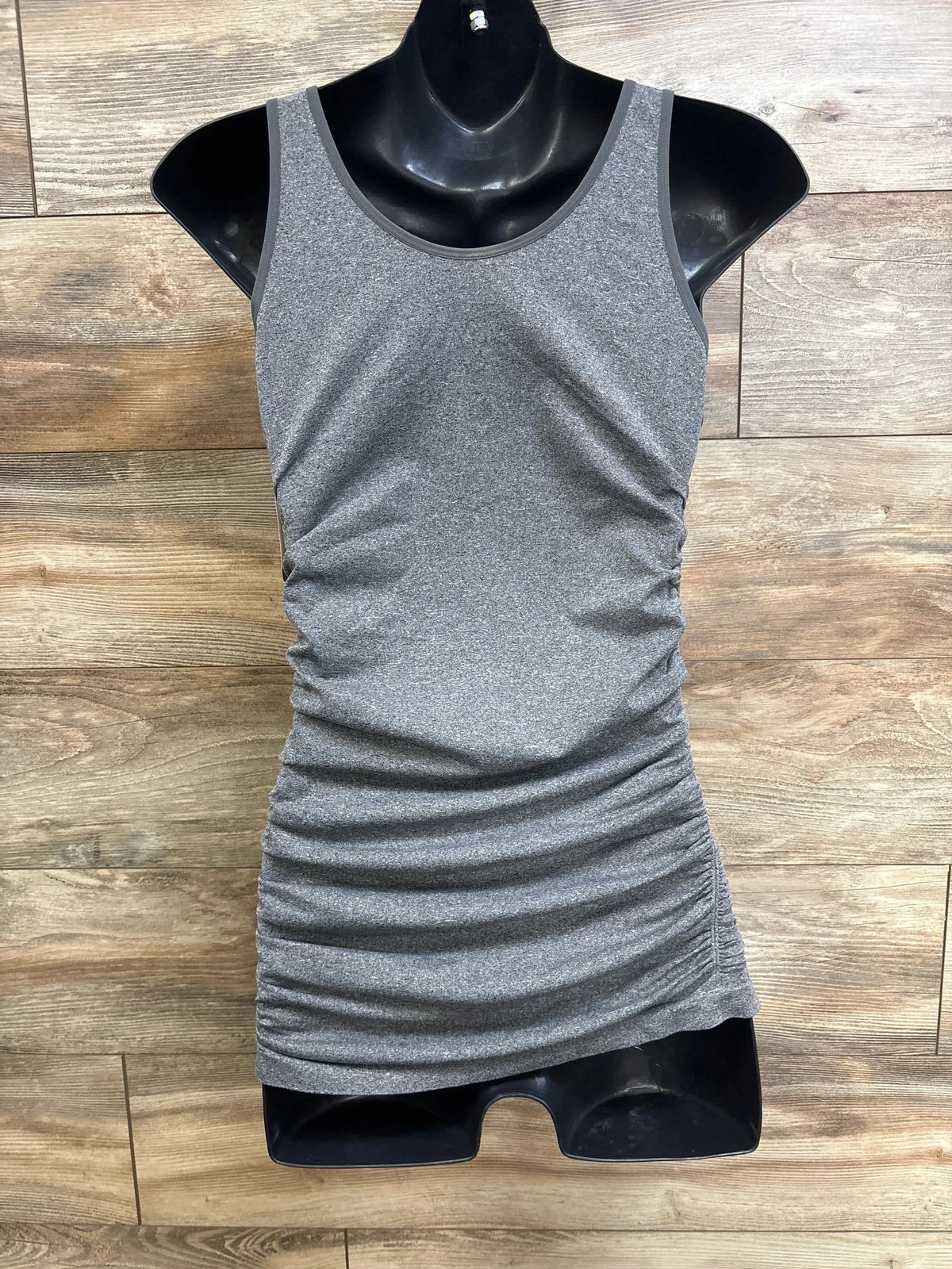 Front view of Isabel maternity ruched tank top in grey with side ruching on black mannequin against wood background