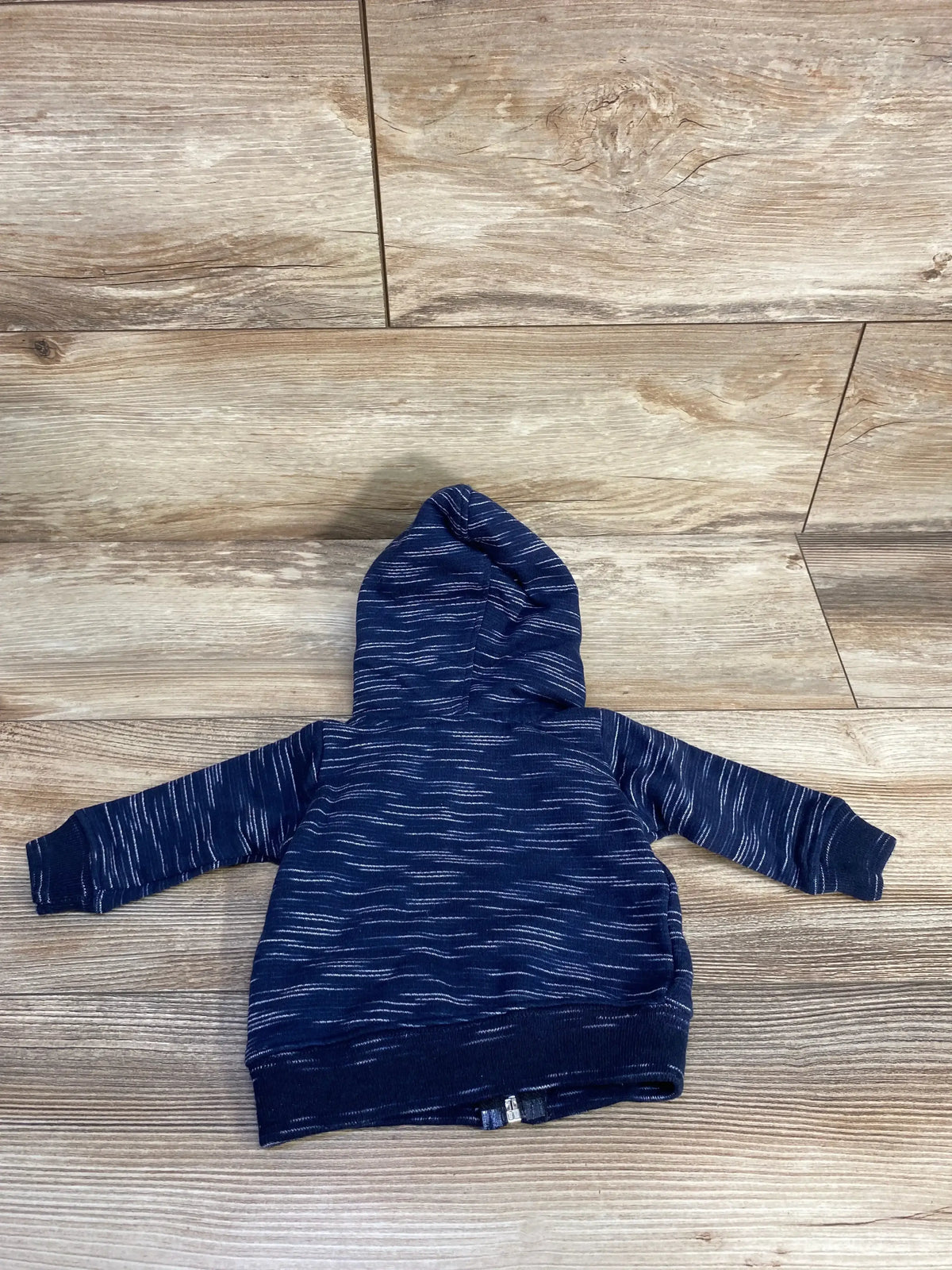 Back view of Svrn Code full-zip navy toddler hoodie showcasing white space-dye stripes on wood plank floor