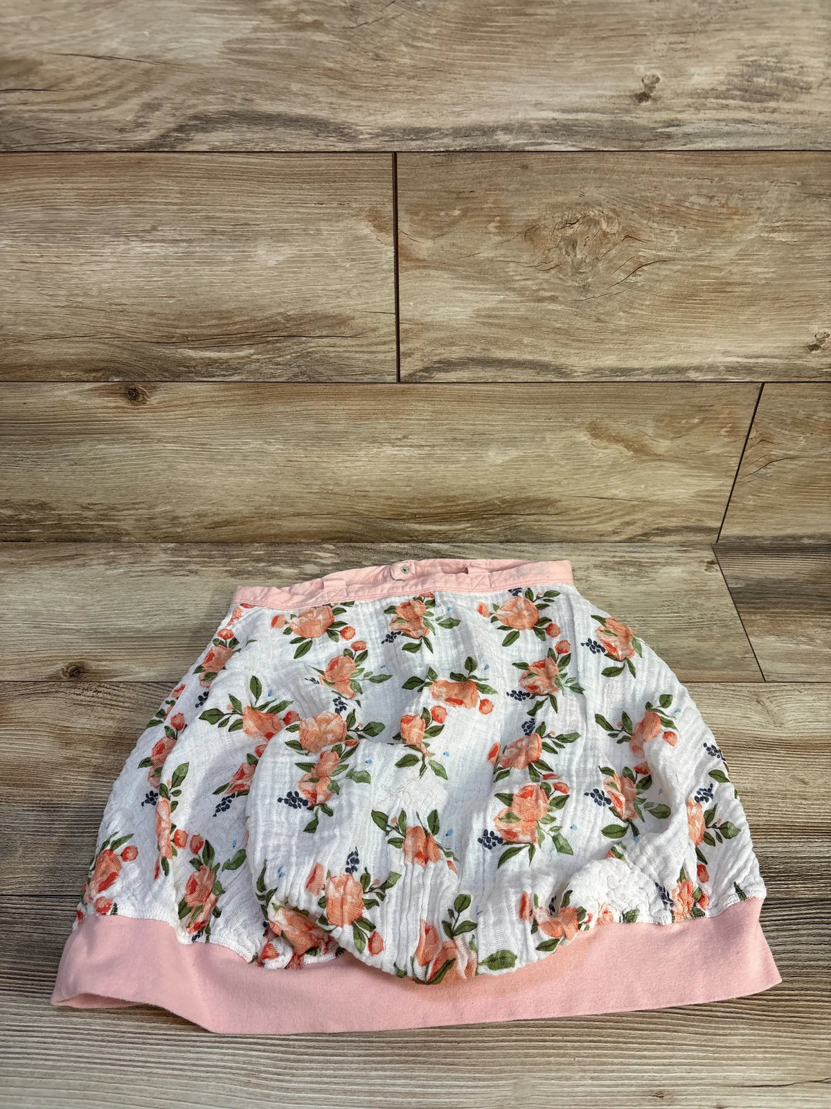 Little Unicorn cotton muslin car seat cover with pink watercolor roses on a wood background