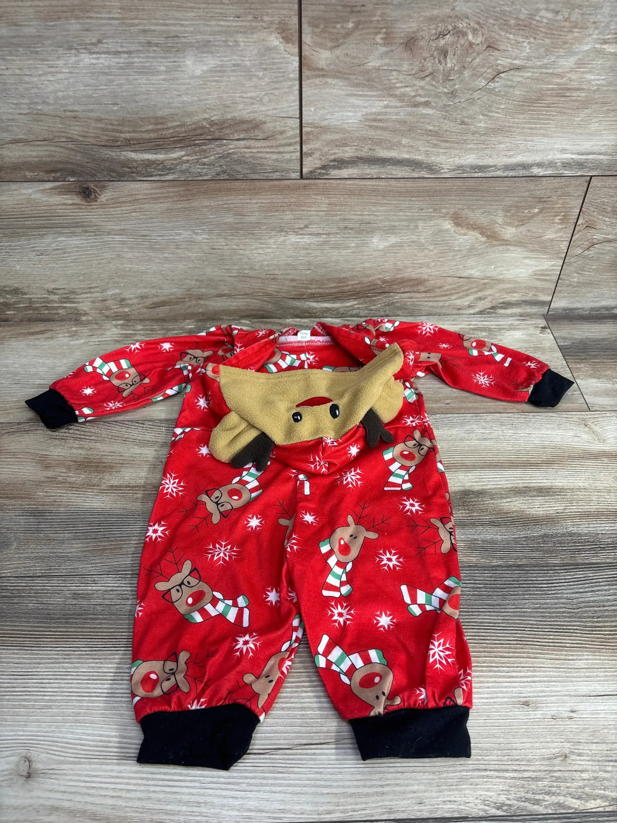 Red reindeer print baby pajamas with 3D hood, snowflakes, and candy canes on wood floor