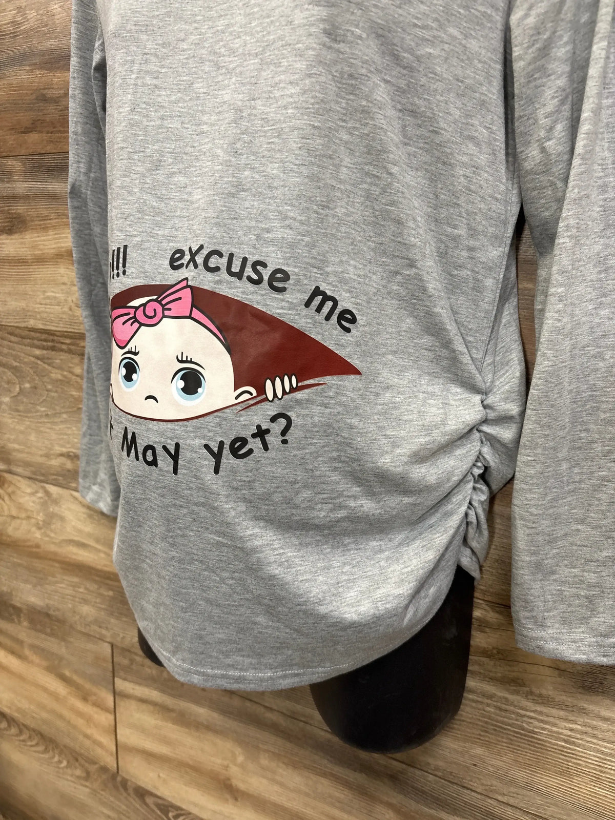 Gray maternity shirt with cute cartoon baby graphic and 'excuse me, may yet?' text