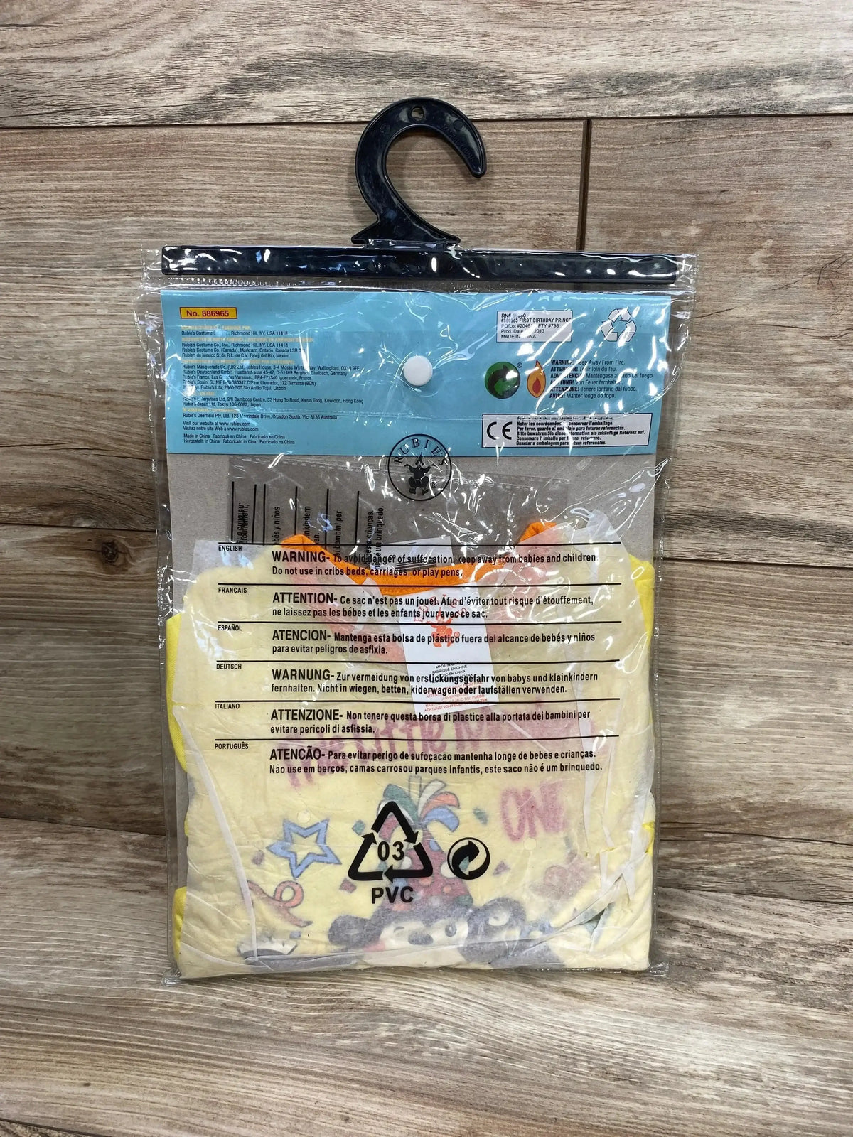 Packaged view of Rubie’s 1st birthday monkey costume, size 6-12 months, showing yellow fabric and colorful graphics on a hanger
