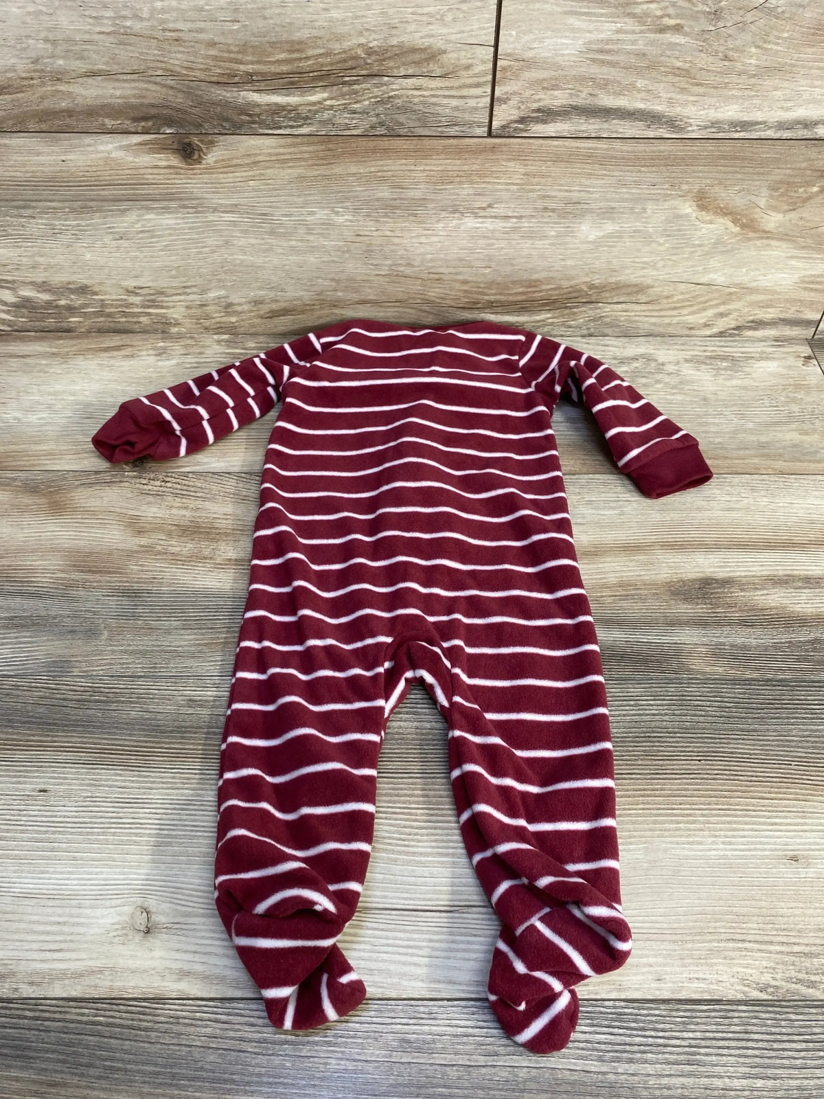 Flat lay of Carter’s red and white striped footed blanket sleeper (size 6M), back view showing long sleeves and enclosed feet on wood background