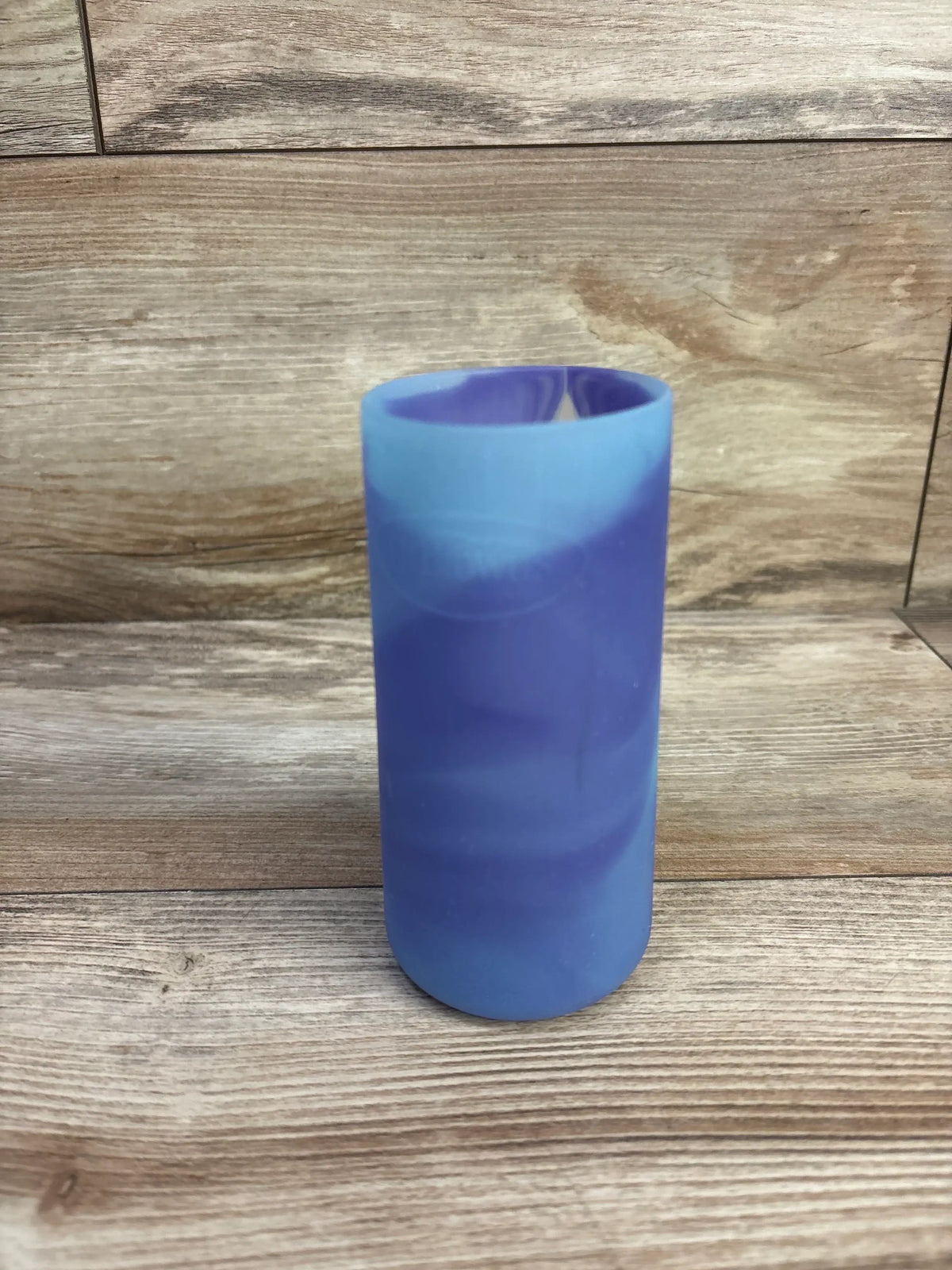 Front view of Dr. Brown's narrow 8 oz silicone bottle sleeve showcasing blue-purple marbled finish with woodgrain surface background