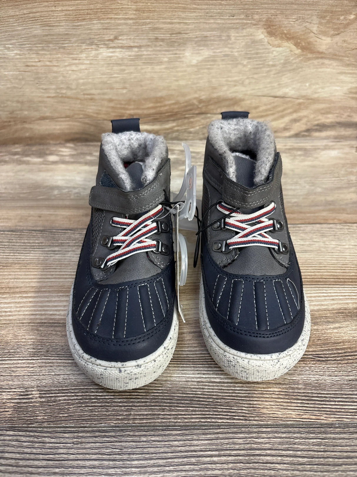 Pair of children's winter boots with navy and gray design, white speckled soles, and fuzzy gray lining