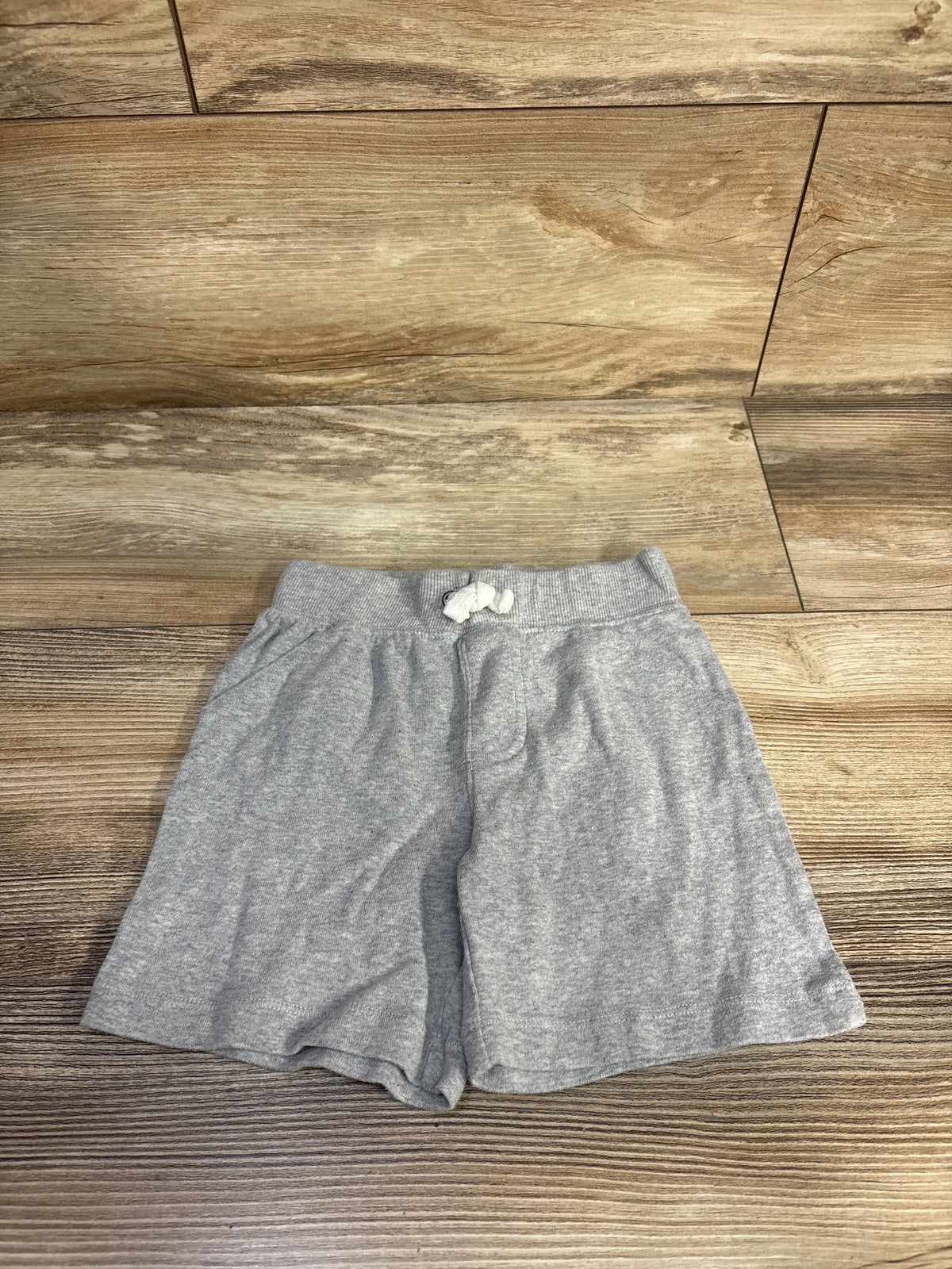 Front view of Carter’s grey drawstring shorts, size 24 months, with elastic waistband and white drawstring on wood flooring