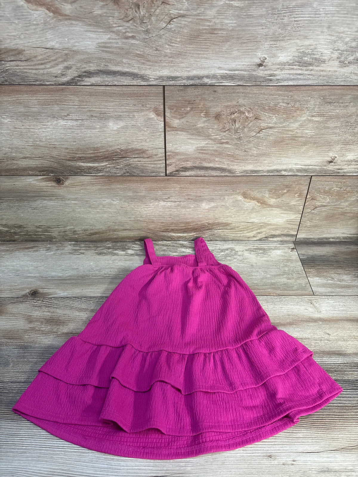 Front view of hot pink Jumping Beans dropped waist knit tank dress with square neckline and tiered skirt on wood background