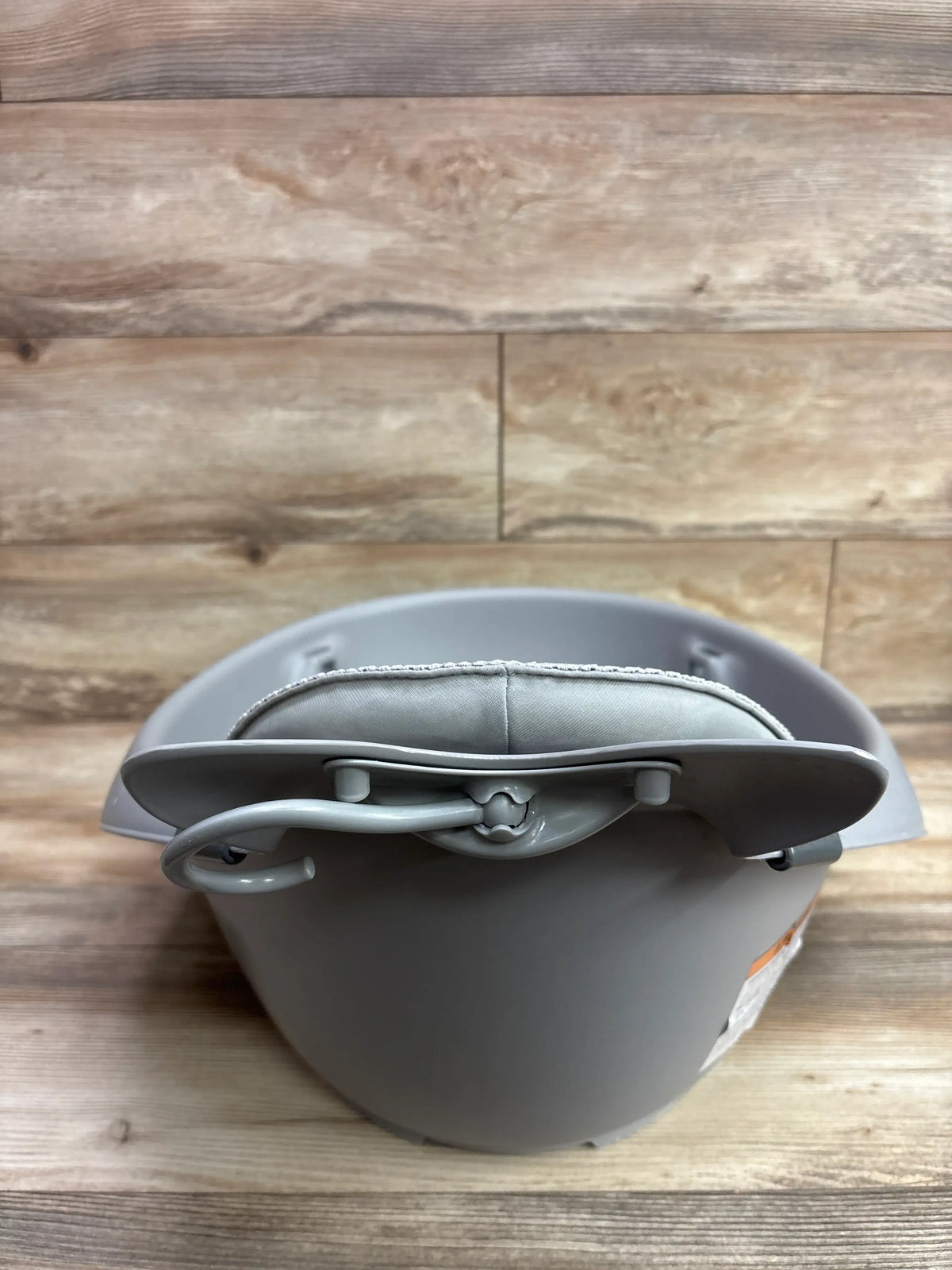 Front view of Skip Hop Moby Smart Sling 3 In 1 Baby Bathtub Grey with sling and support bar on a wood background