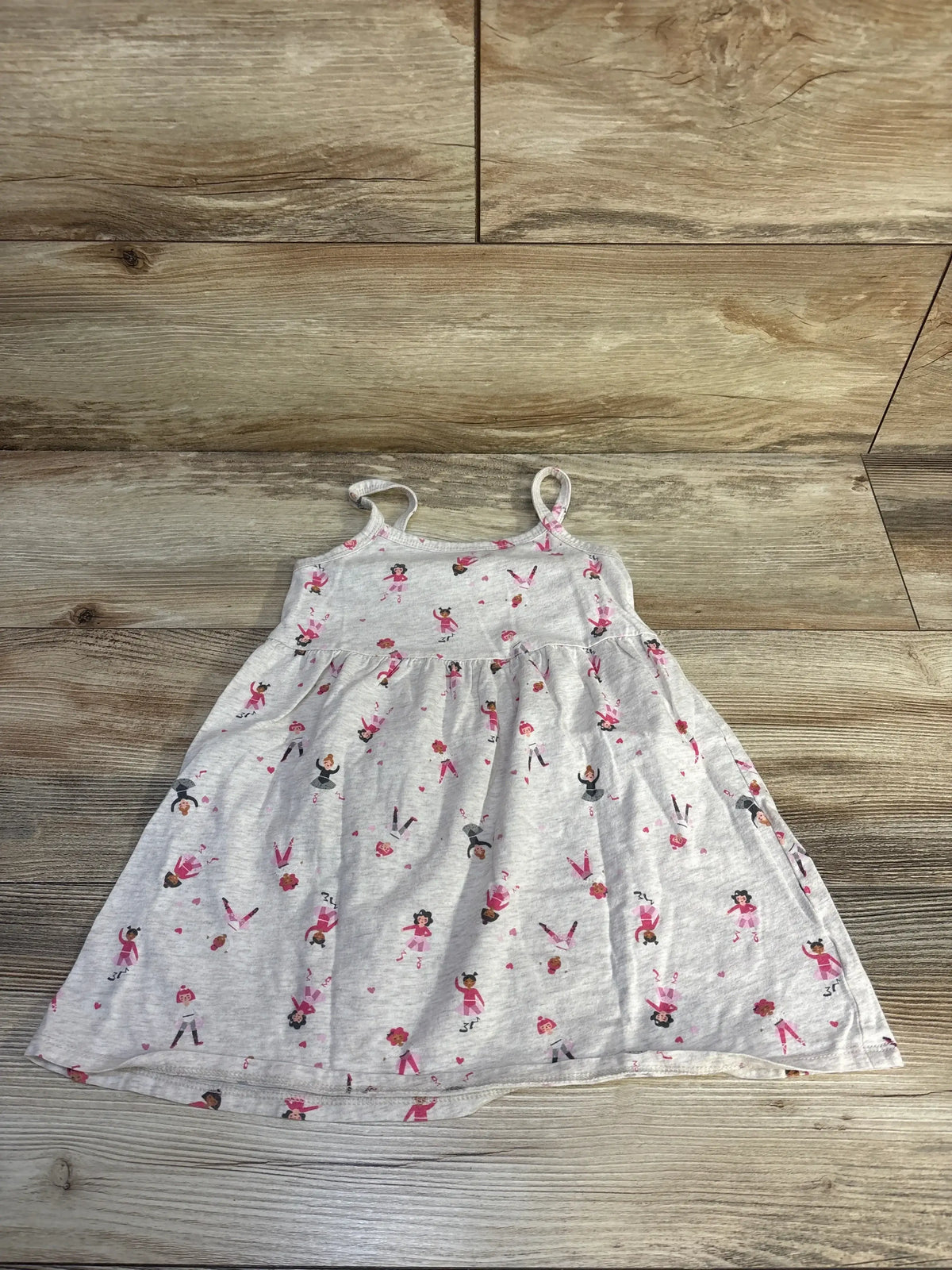 Flat lay of girls' Old Navy oatmeal 3T dress with spaghetti straps, gathered skirt and pink ballerina print on wood background