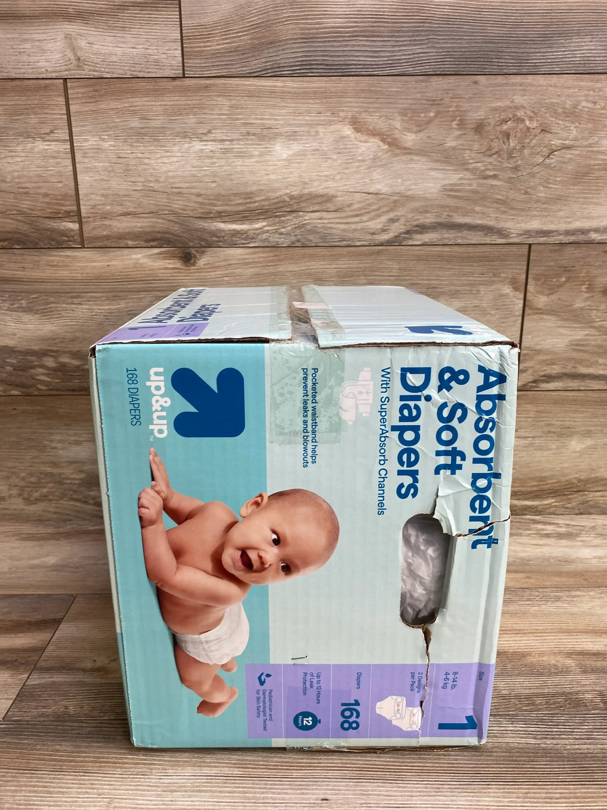 Up & Up size 1 baby diapers box, 168 count, with infant photo on wood floor