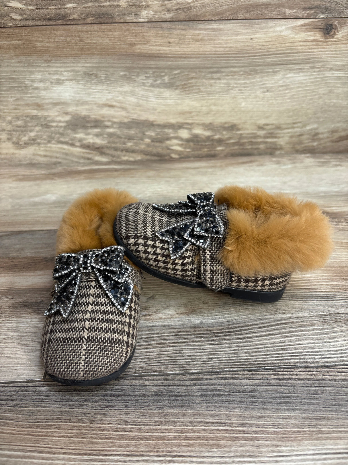 Plaid fur-lined children's loafers with rhinestone bow, brown wood background
