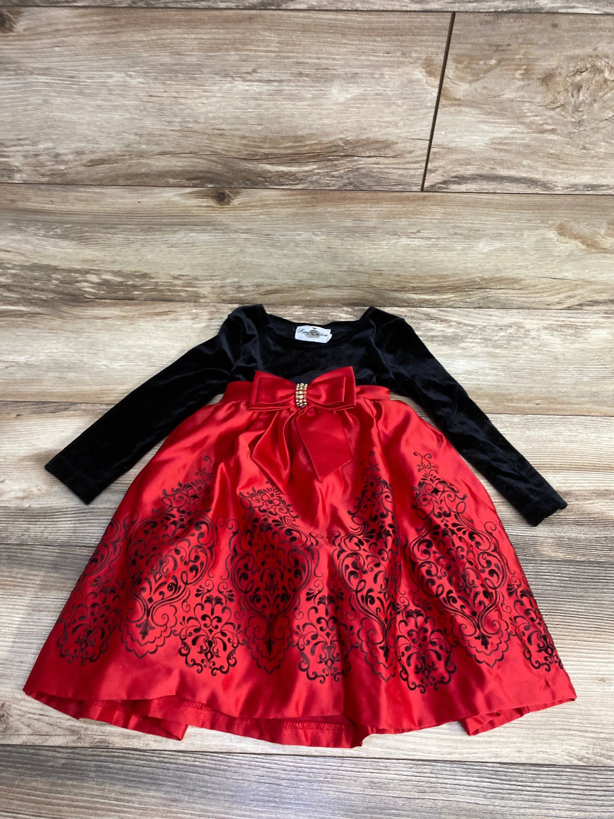 Girls' holiday dress with black velvet top, long sleeves, red satin skirt, bow and floral pattern