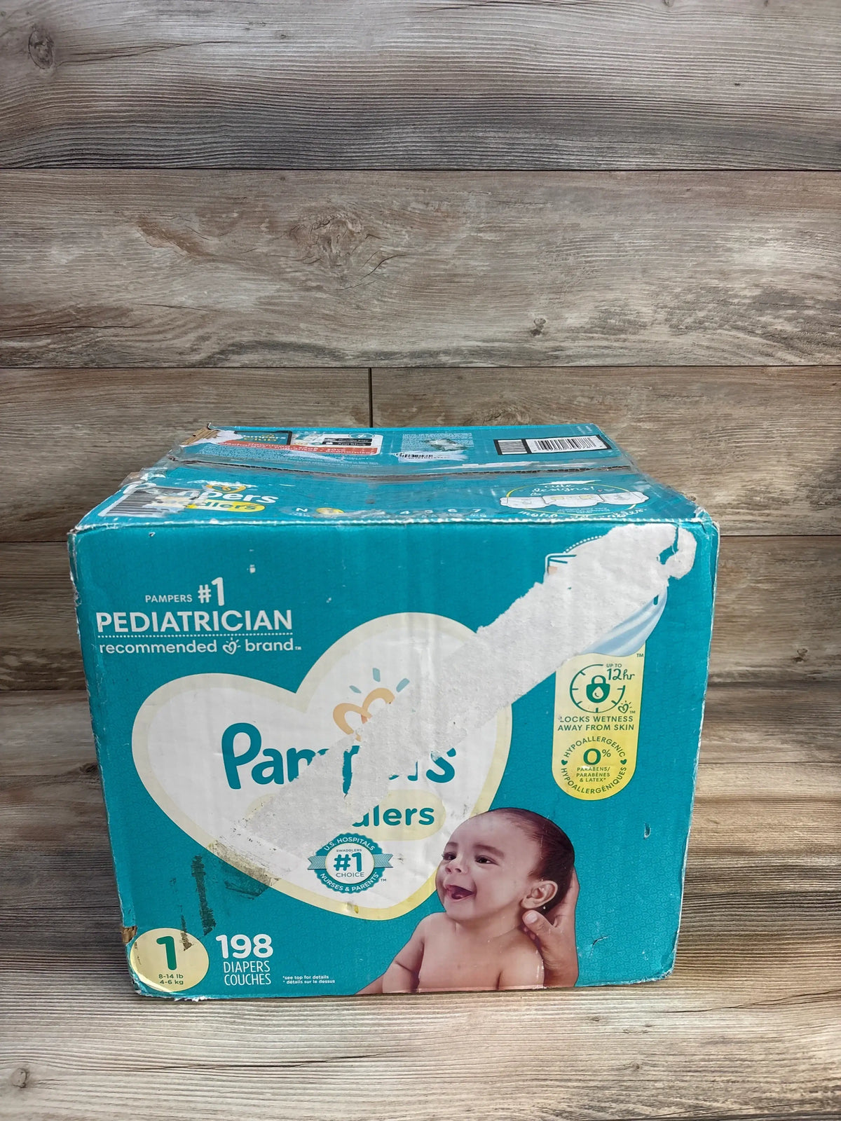 Front of Pampers Swaddlers Size 1 198-count diaper box with pediatrician recommended label, baby photo, worn teal packaging