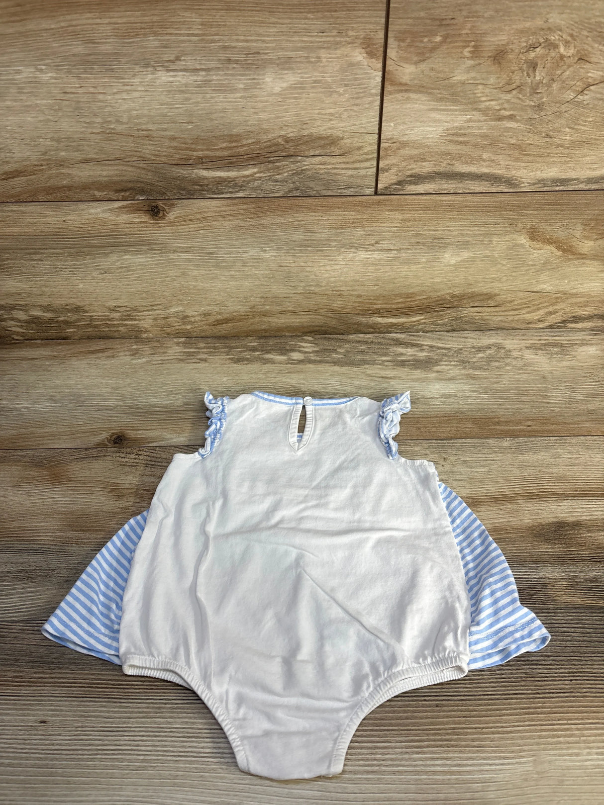 Flat lay of blue and white striped bodysuit dress (18M) showing ruffle sleeves and striped side panels on light wood floor