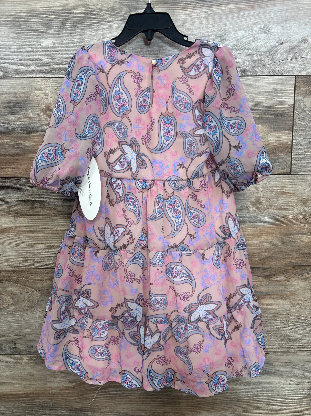 Front view of Ava & Yelly kids’ paisley tiered dress in blush showcasing puff sleeves and a three-tier ruffle skirt