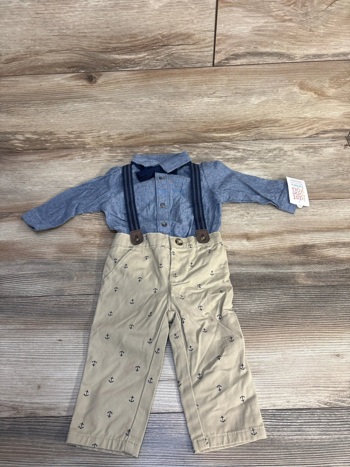 Toddler's nautical outfit with blue long-sleeve shirt, navy suspenders, bow tie, and beige anchor-patterned pants