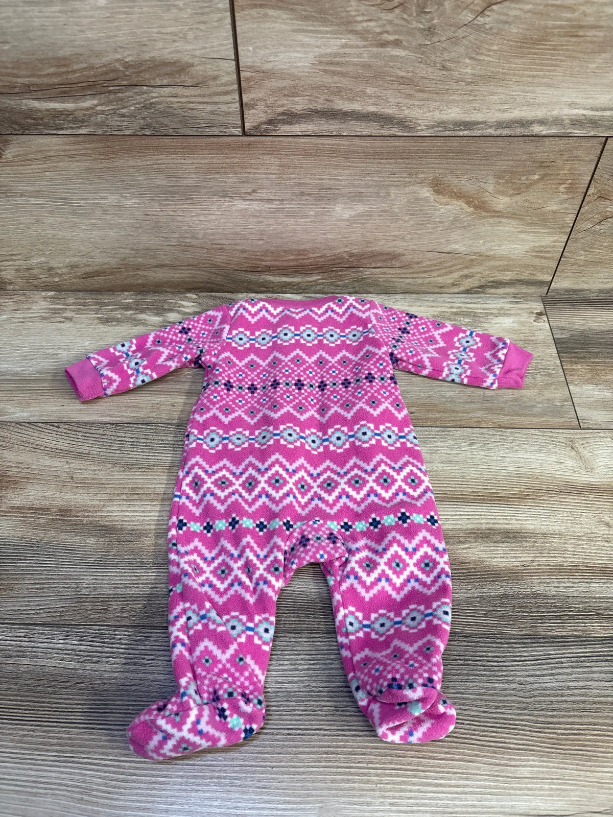 Pink and white patterned newborn blanket sleeper by Me n Mommy To Be on a wood background